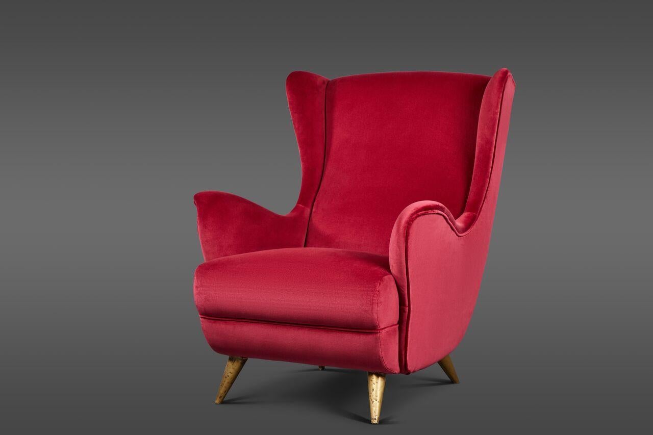 A beautifully sculptural pair of wingback Italian lounge chairs, in the manner of Gio Ponti. Upholstered in a red raspberry velvet.