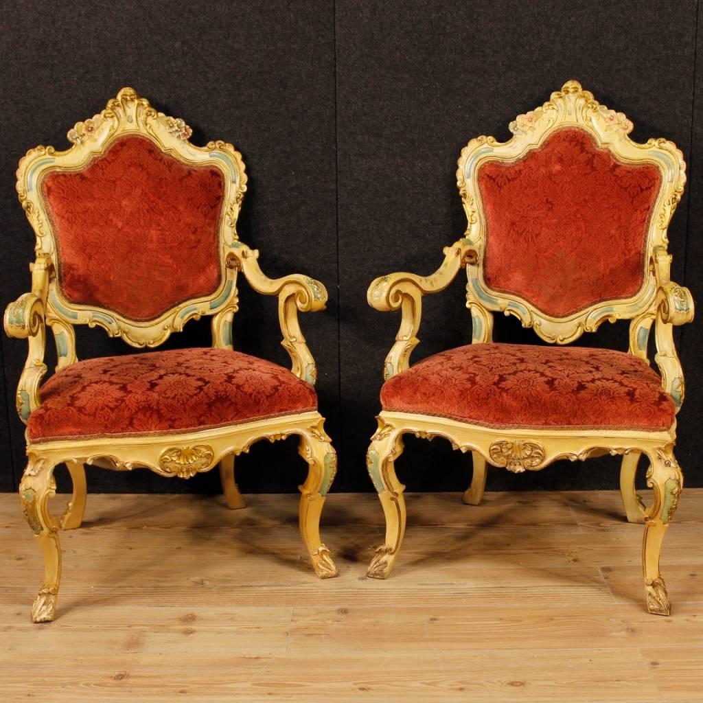 Pair of Venetian armchairs from the 20th century. Furniture in carved, gilded and lacquered wood of great decoration. Armchairs covered with red floral fabric in good condition. Comfortable seats with padding in good condition. Measures: Height to