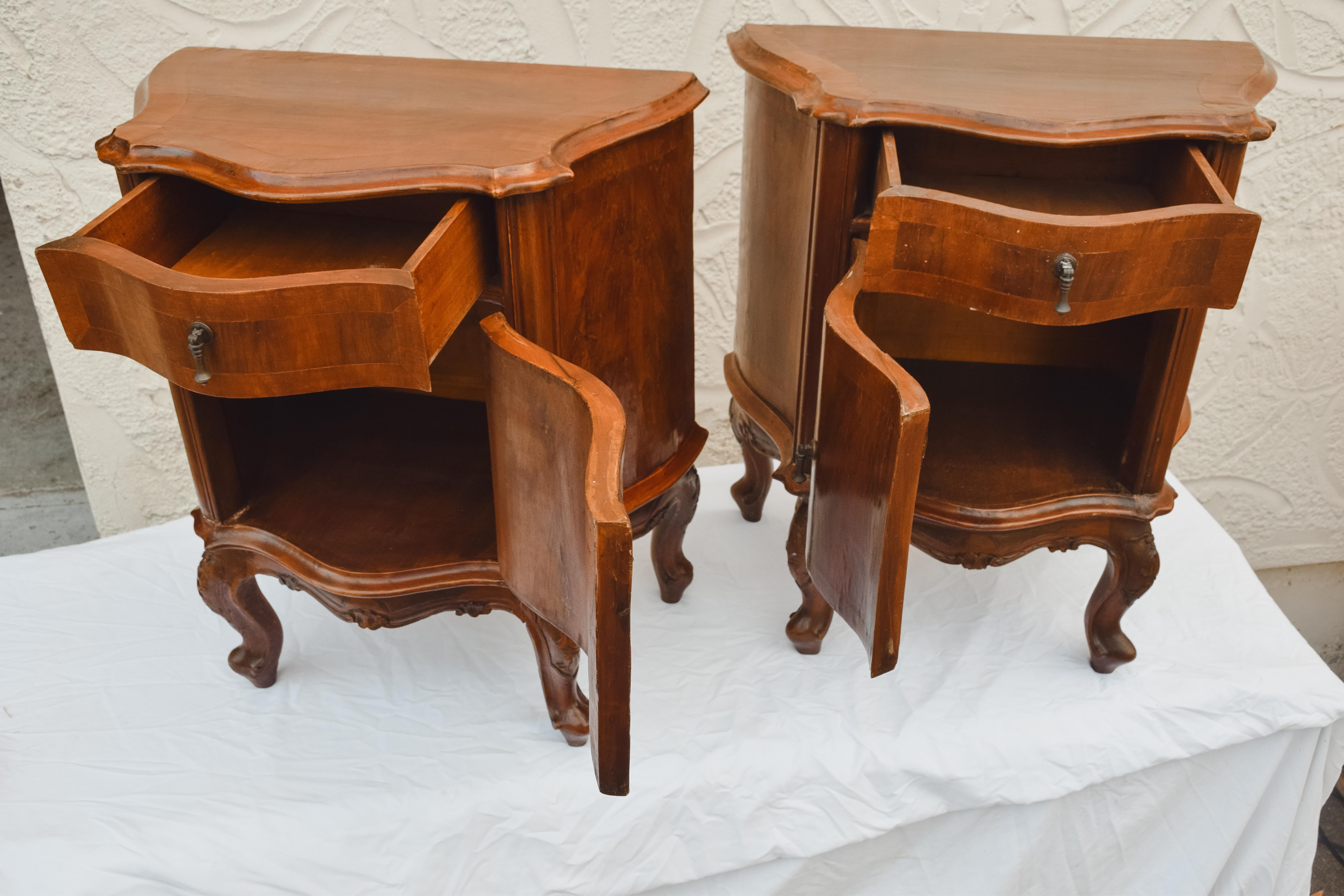 Pair of Mid Century Italian bedside tables. Wavy and rounded furniture in walnut and beech woods with beautiful lines. Bedside tables with one door of good capacity and a functional drawer. On the smaller size for typical American decor but nicely