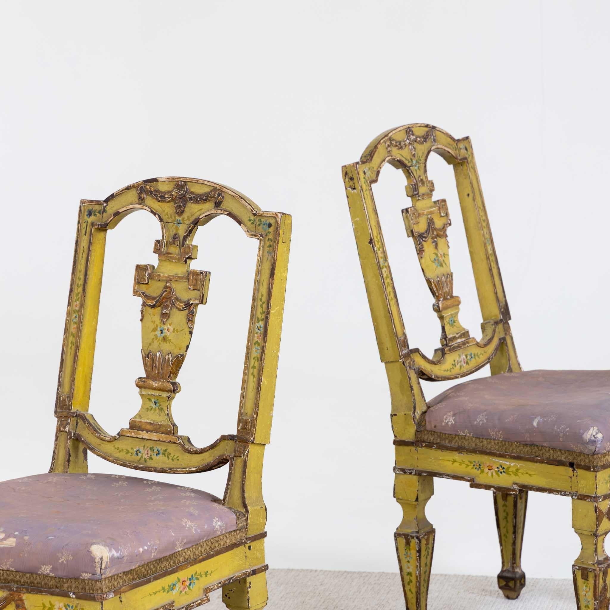 Pair of upholstered Venetian chairs on square-pointed legs with yellow-painted wooden frames with polychrome floral painting and festoons in relief. The backrest is designed as a lidded urn in the central bar. The chairs are in an unrestored