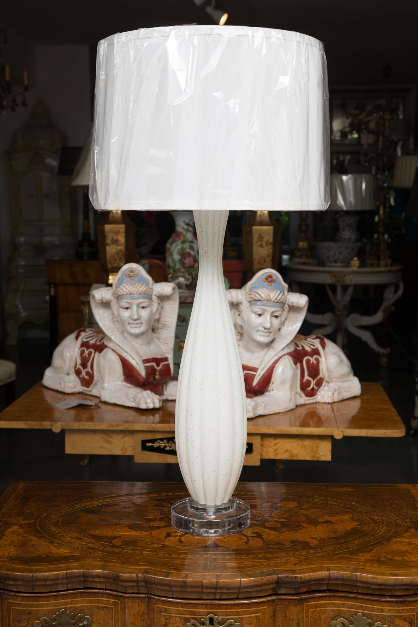 This is a good quality pair of Venetian hand blown glass as table lamps. The vase has been capped with plexiglass and is situated on a double stepped plexiglass base, as well. The lamps are fluted - white, with subtle flecks of gold, 20th century.