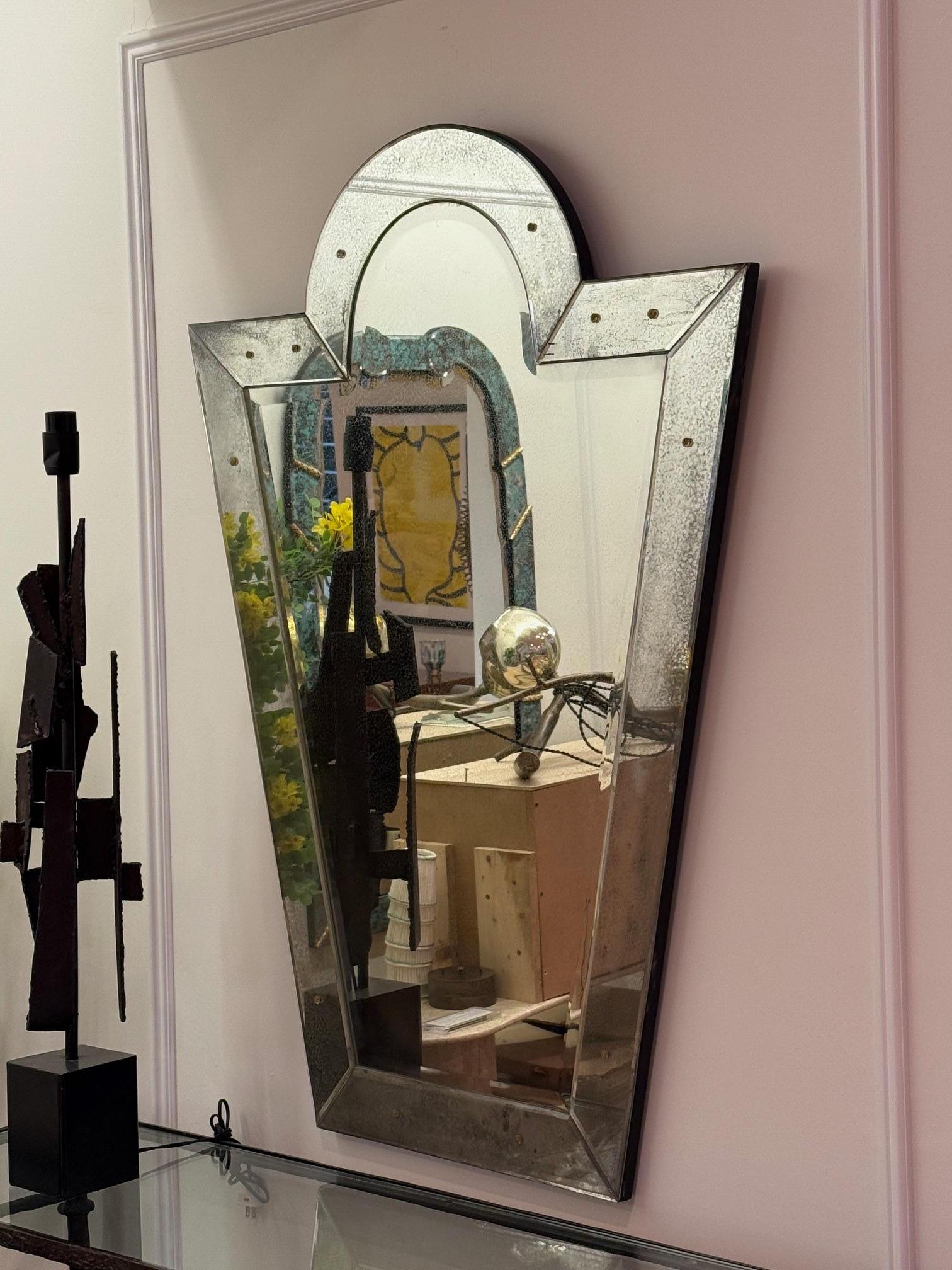 Pair of Venetian 'Key Hole' Shaped Beveled Glass Mirrors Hollywood Regency Style

Pair of Venetian key hole shaped mirrors. The center beveled panel mirror flanked by six beveled sided mirrored panels. 36' wide tapering down to 20