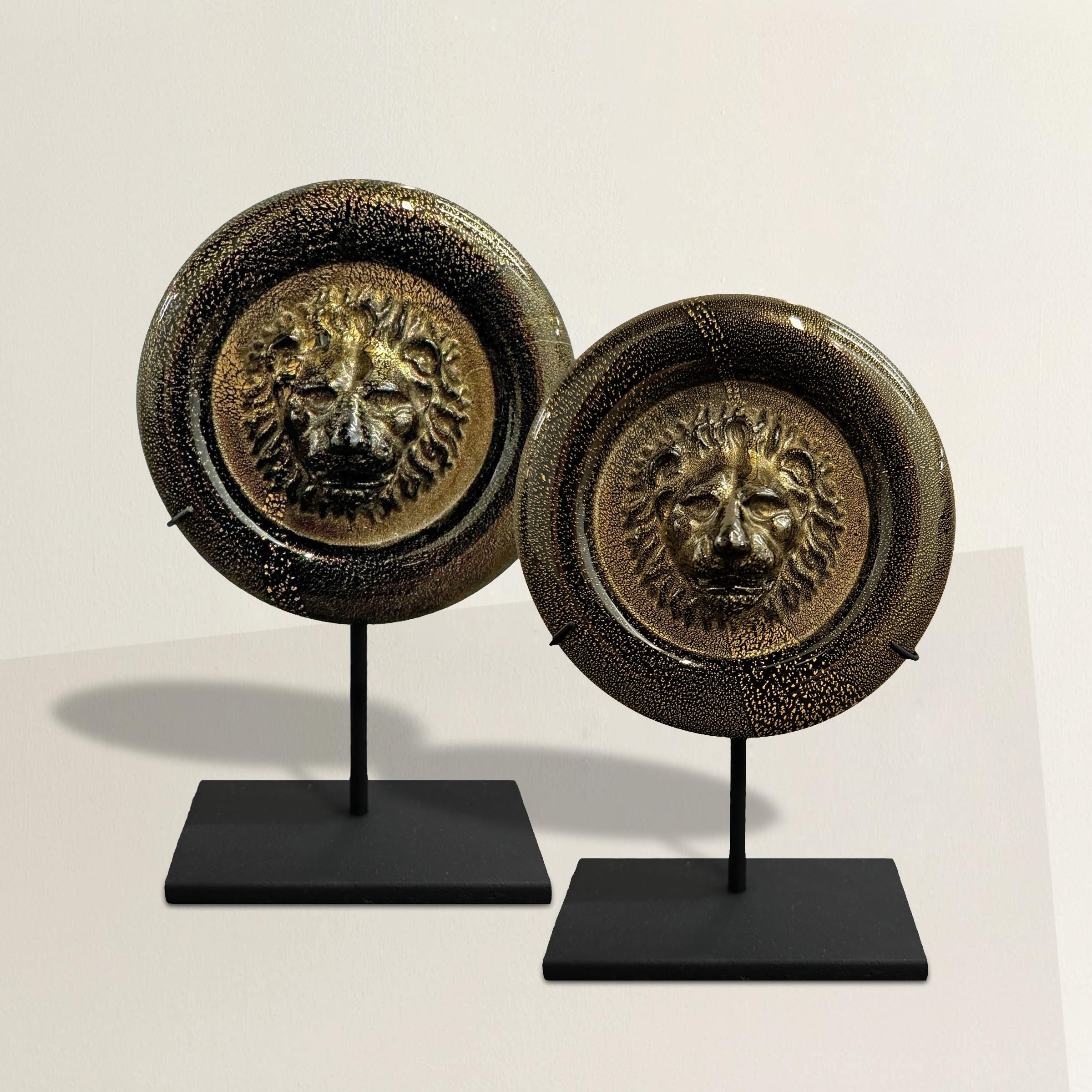 This pair of vintage Italian Venetian Murano glass medallions is a stunning example of exquisite craftsmanship. Each medallion features a lion's head pressed into the center, symbolizing strength and nobility. The glass is a deep, lustrous black,