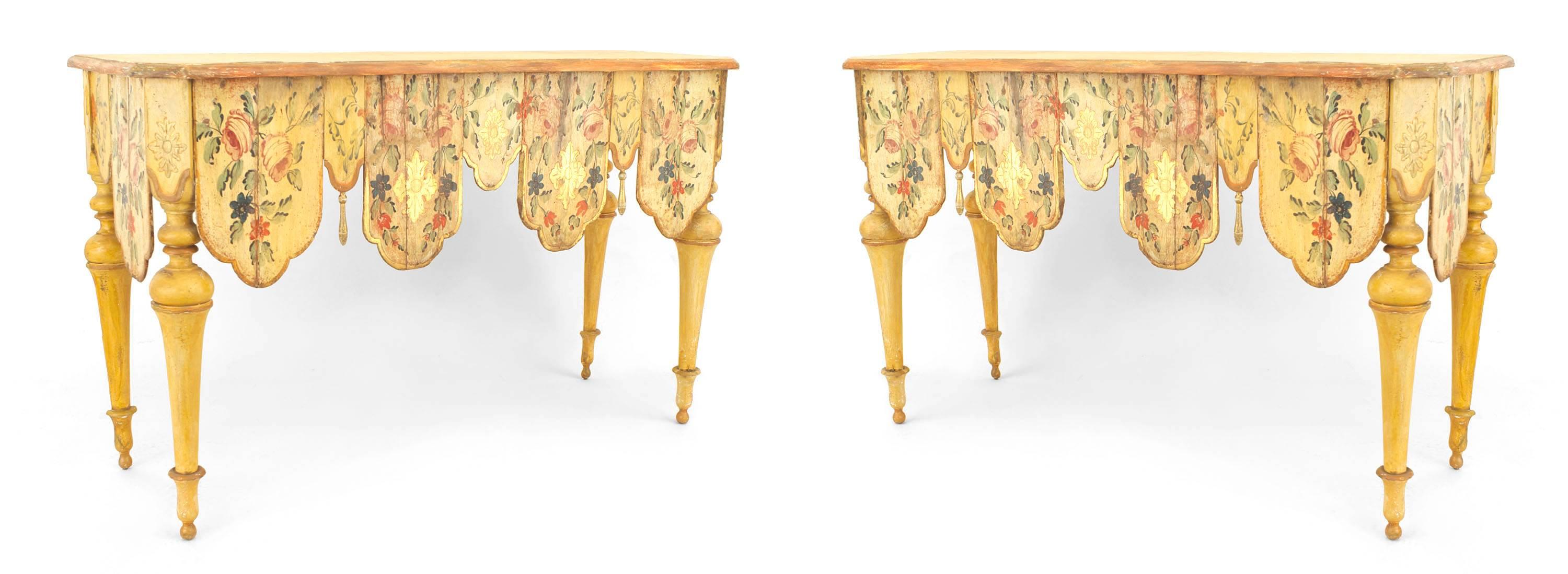 Pair of Venetian style polychrome painted console tables with shaped aprons carved with tassels and painted with floral designs.