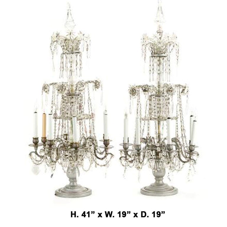 An exceptional pair of large Venetian rock crystal and cut crystal silver-wood 8-light girandoles, 19th century. 
Each girandole topped with a crystal final, above a crystal stem with three tiers, each decorated with unique shaped rock crystal drops