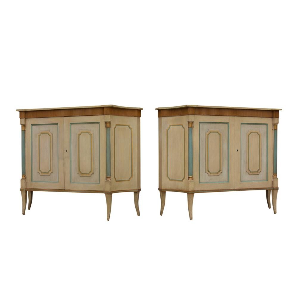 This pair of Regency style painted servers by Baker furniture has the original ivory, light green, amber colored combination painted finish. The top features curve design on the sides, single inner shelf, symmetrical molding on the two doors and