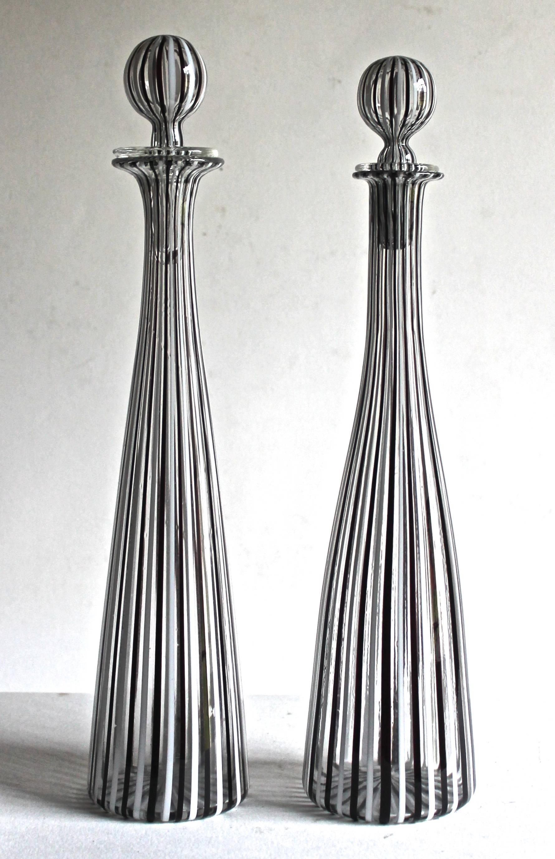 A rare pair of Venini Morandiane black and white vertical stripped carafes, with stoppers. By Gio Ponti, circa 1950. The slightly larger is 37 cm. in height. 
 Both signed with the three line signature: 'Venini Murano Italia'.