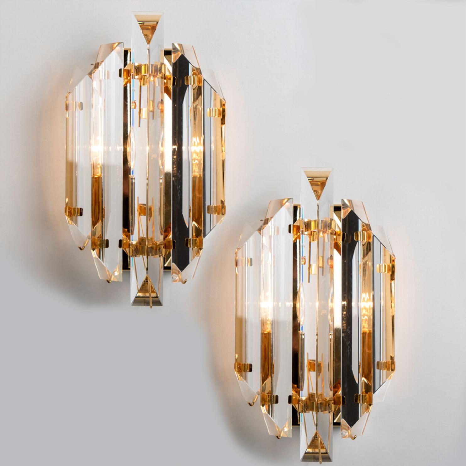 Beautiful tube shaped glass wall sconces featuring five long crystal clear glass tube-like rods, with brass details and back plate. Illuminates beautifully. High-end pieces.

Cleaned and well-wired, in full working order and ready to use. The brass