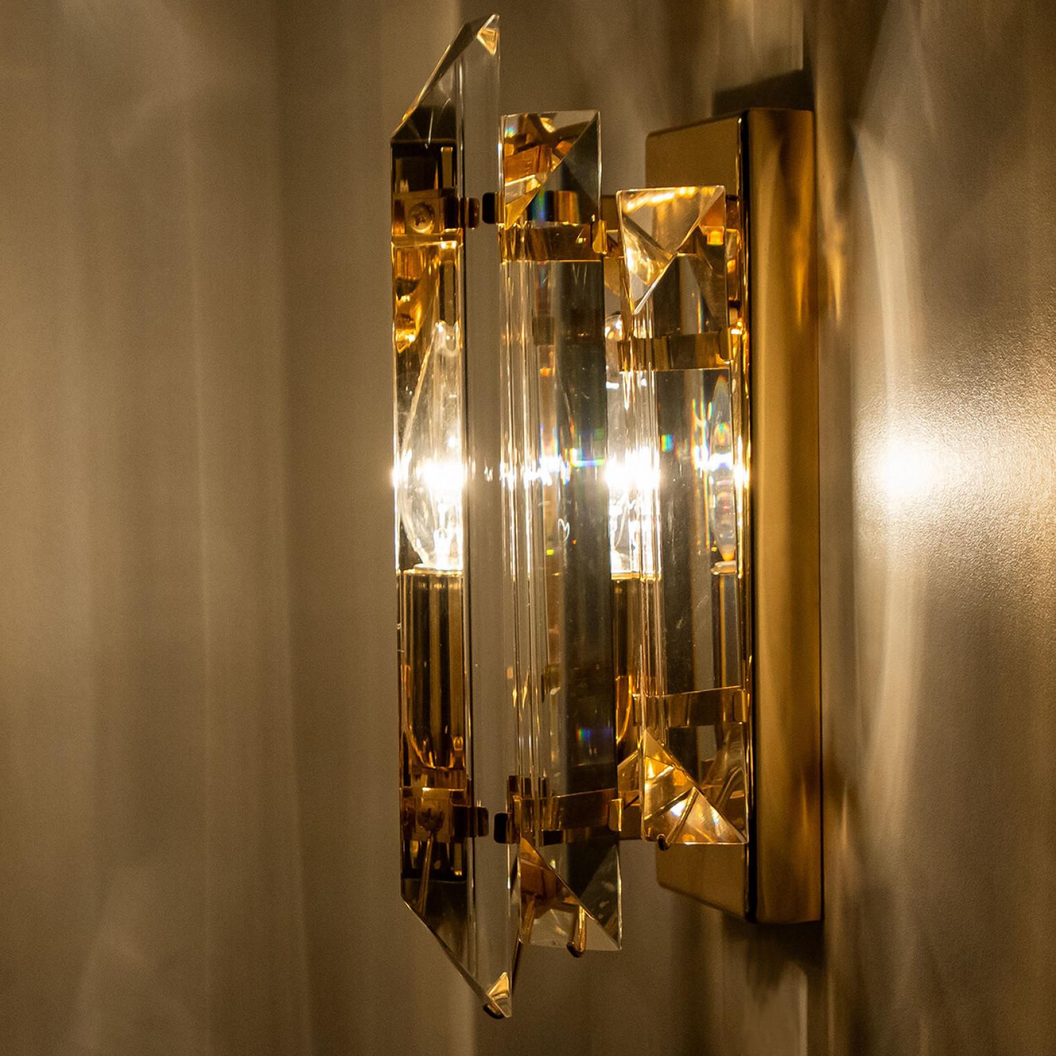 Beautiful tube shaped glass wall sconces featuring five long crystal clear glass tube-like rods, with brass details and back plate. Illuminates beautifully. High-end pieces.

Cleaned and well-wired, in full working order and ready to use. The brass