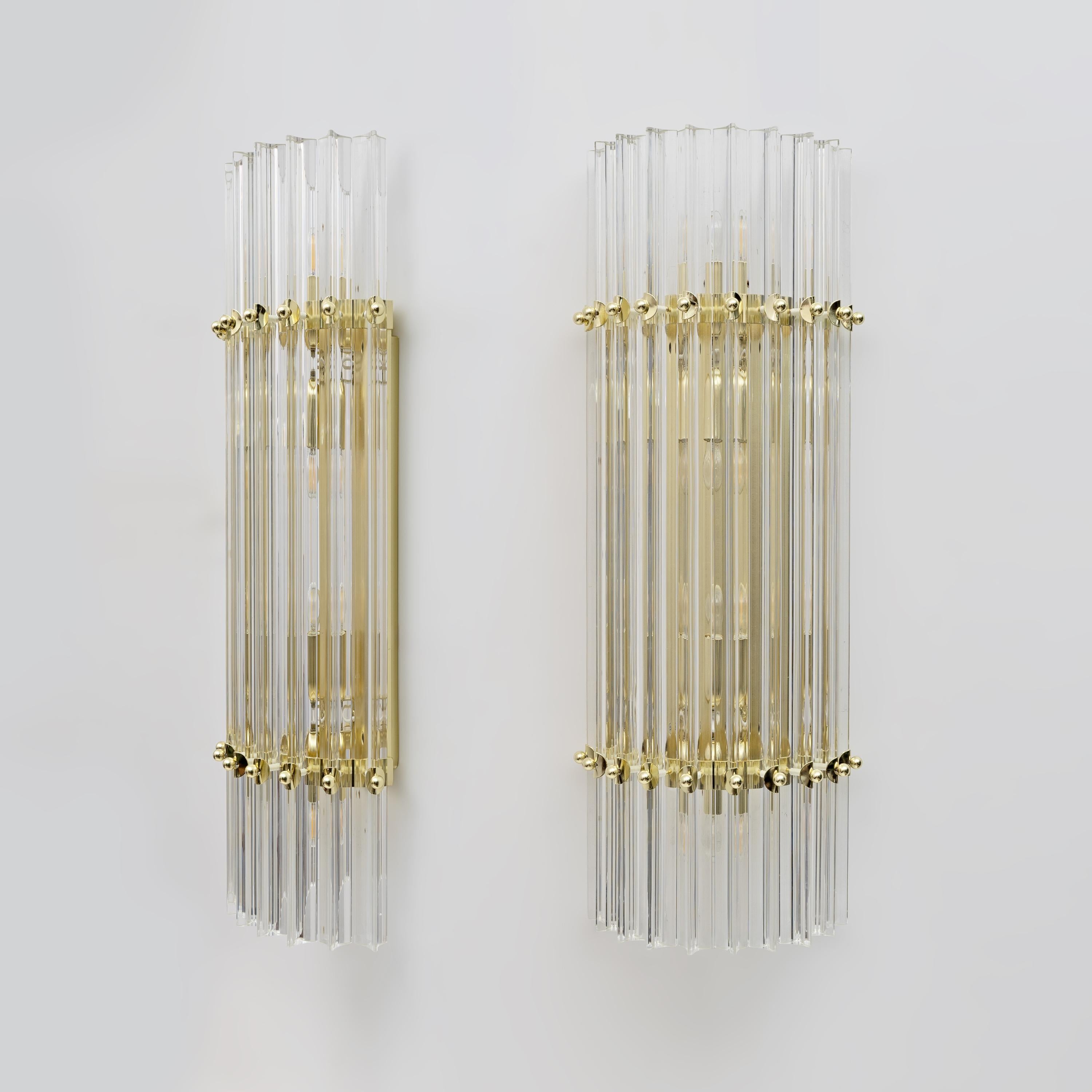Cette paire d'appliques murales se compose de 10 trièdres, chacun en cristal de Murano, fabriqués dans le style Venini, avec un cadre en laiton et en métal doré.
Quatre ampoules sont nécessaires, avec un culot E27 pour l'Europe ou un culot E26 pour