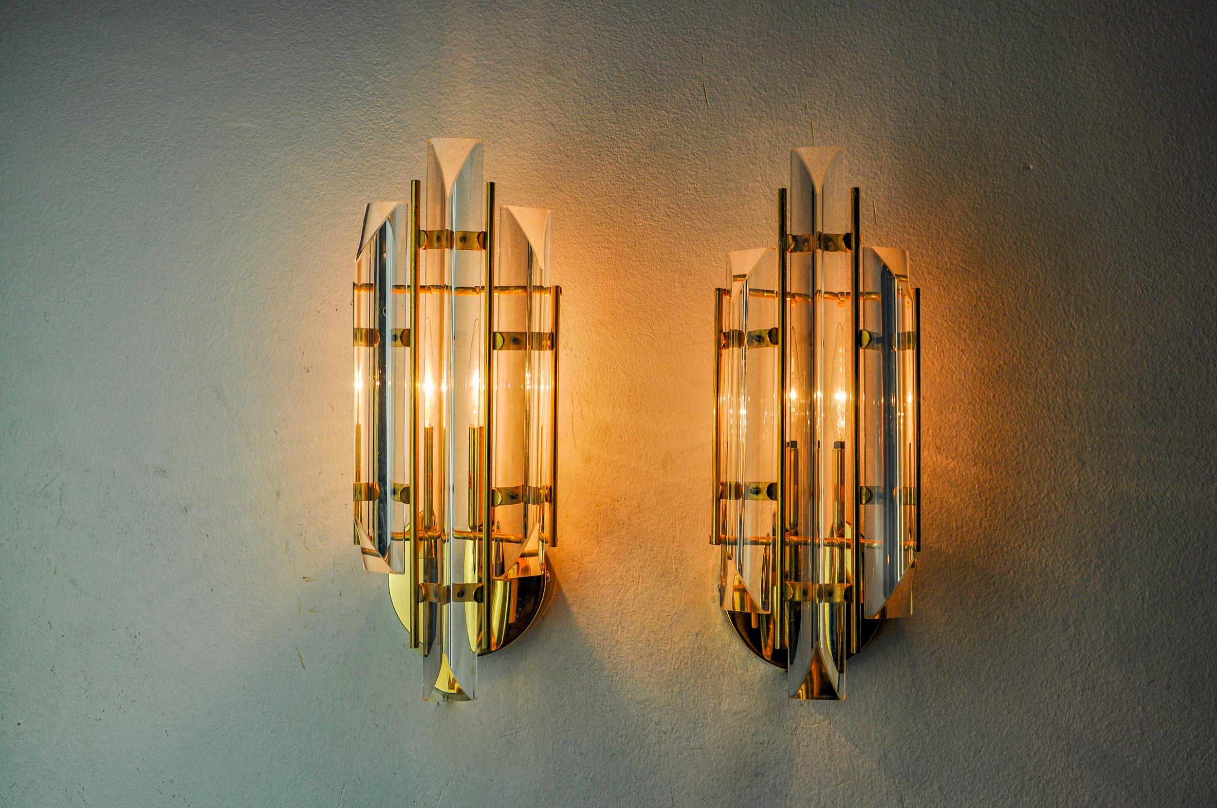 Très belle paire d'appliques Venini produites en Italie dans les années 70. Verre taillé et structure en métal doré. Objet unique qui illuminera à merveille et apportera une véritable touche design à votre intérieur. Électricité vérifiée, marque de