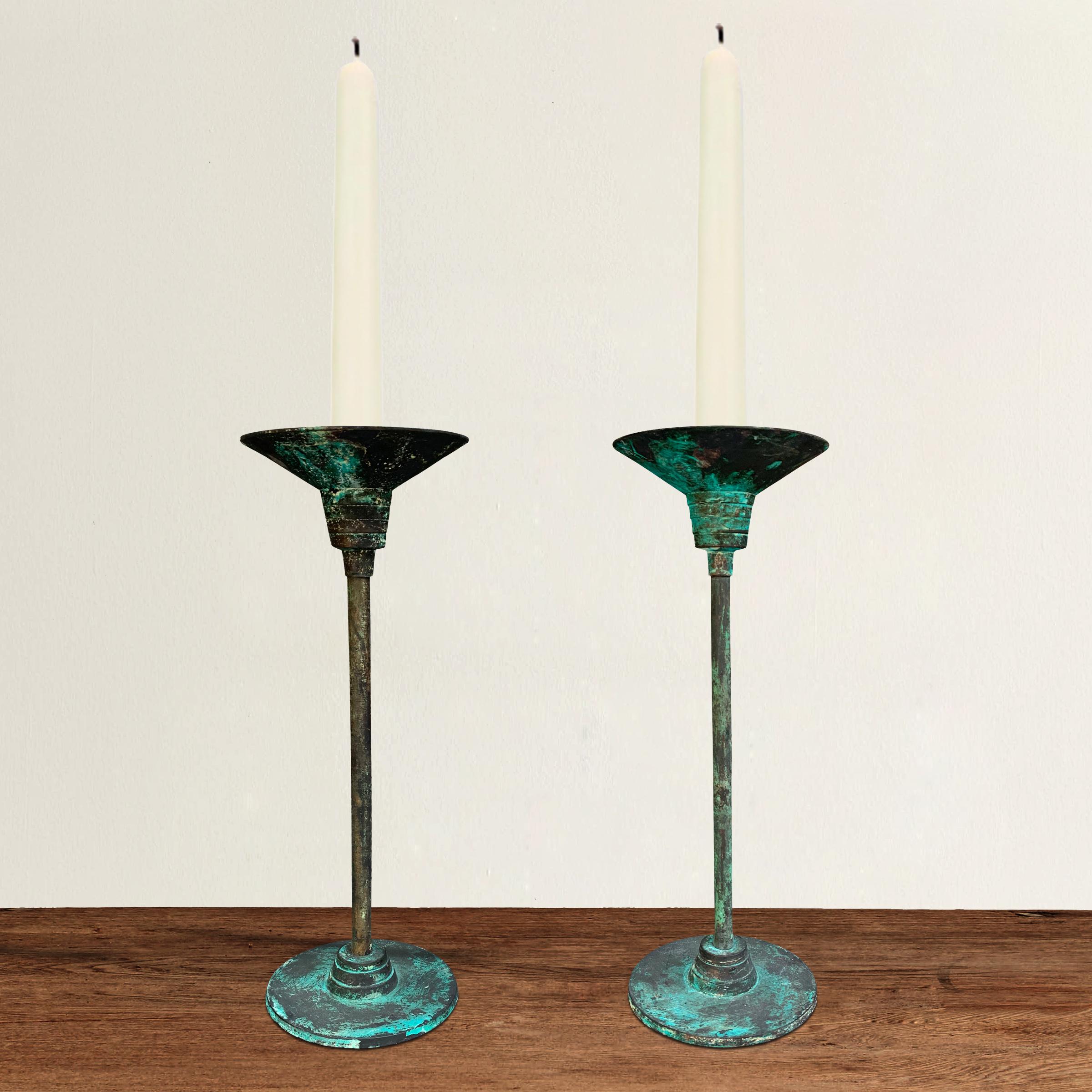 A pair of vintage bronze candlesticks with a fantastic neoclassical Roman form with a wonderful rich verdigris finish covering the entirety of each piece. Beautiful in any style interior!