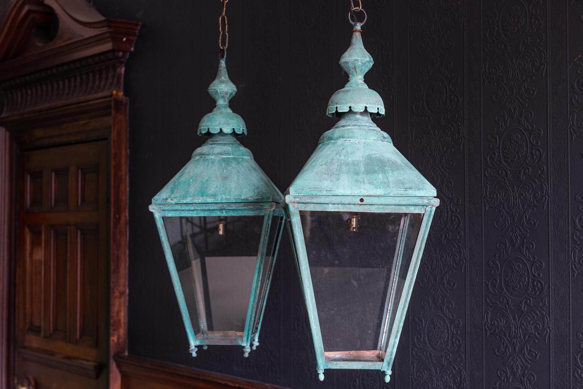 Pair of Verdigris copper lanterns,
circa 1940.

With screw fit canopies for bulb removal and interesting quarter foil cut shapes to the bases

They come with 1m of silk flex, 1m of heavy gauge antique brass chain and bronze ceiling