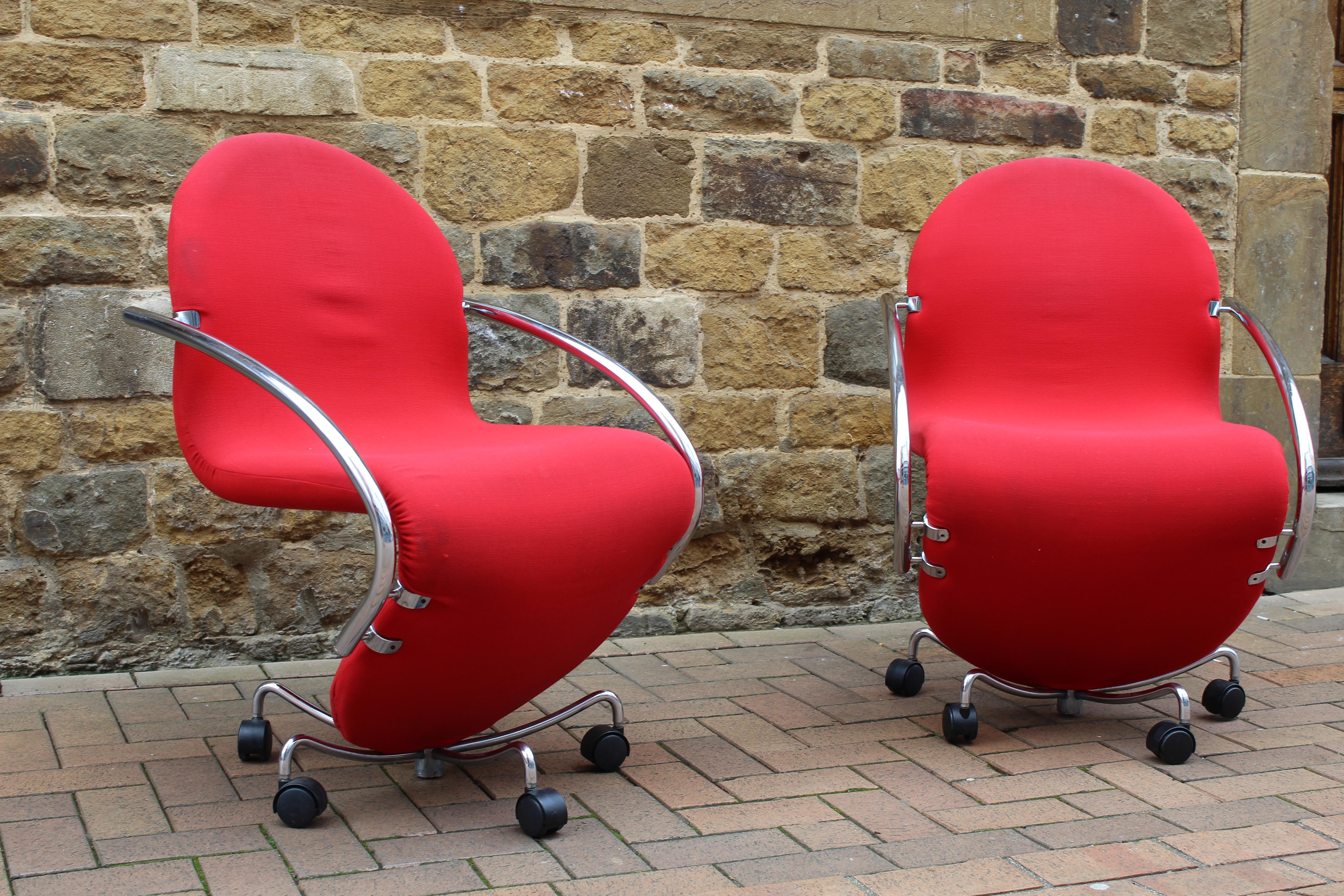 This is a pair of very rare Mid-Century Modern Verner Panton 'System123 - Easy Chairs', designed in 1974 and manufactured by Fritz Hansen, in their original red upholstery with chrome arms and set on a five stem swivel base with casters.

This