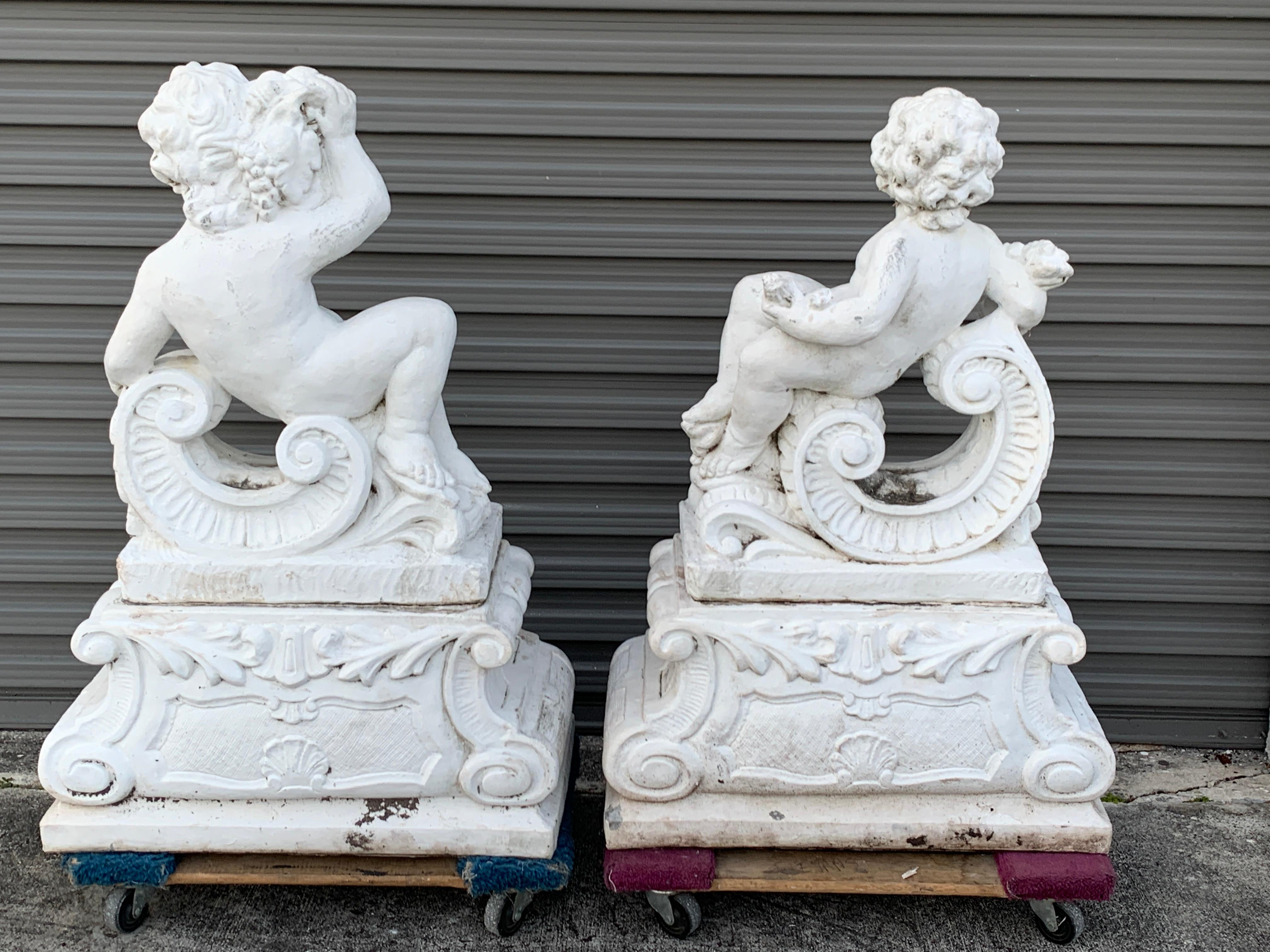 20th Century Pair of Vintage Cast Stone Statues of Recumbent Putti on Pedestal Bases