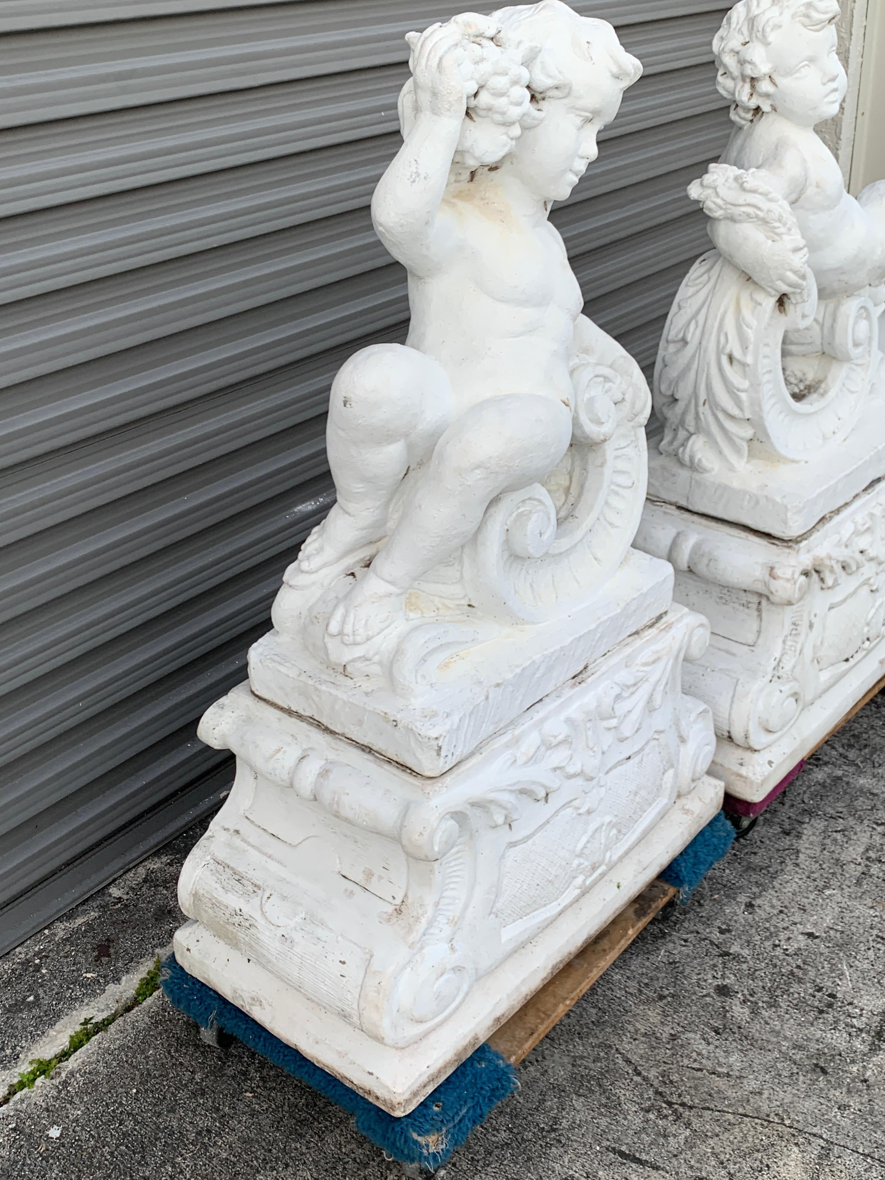 Polychromed Pair of Vintage Cast Stone Statues of Recumbent Putti on Pedestal Bases