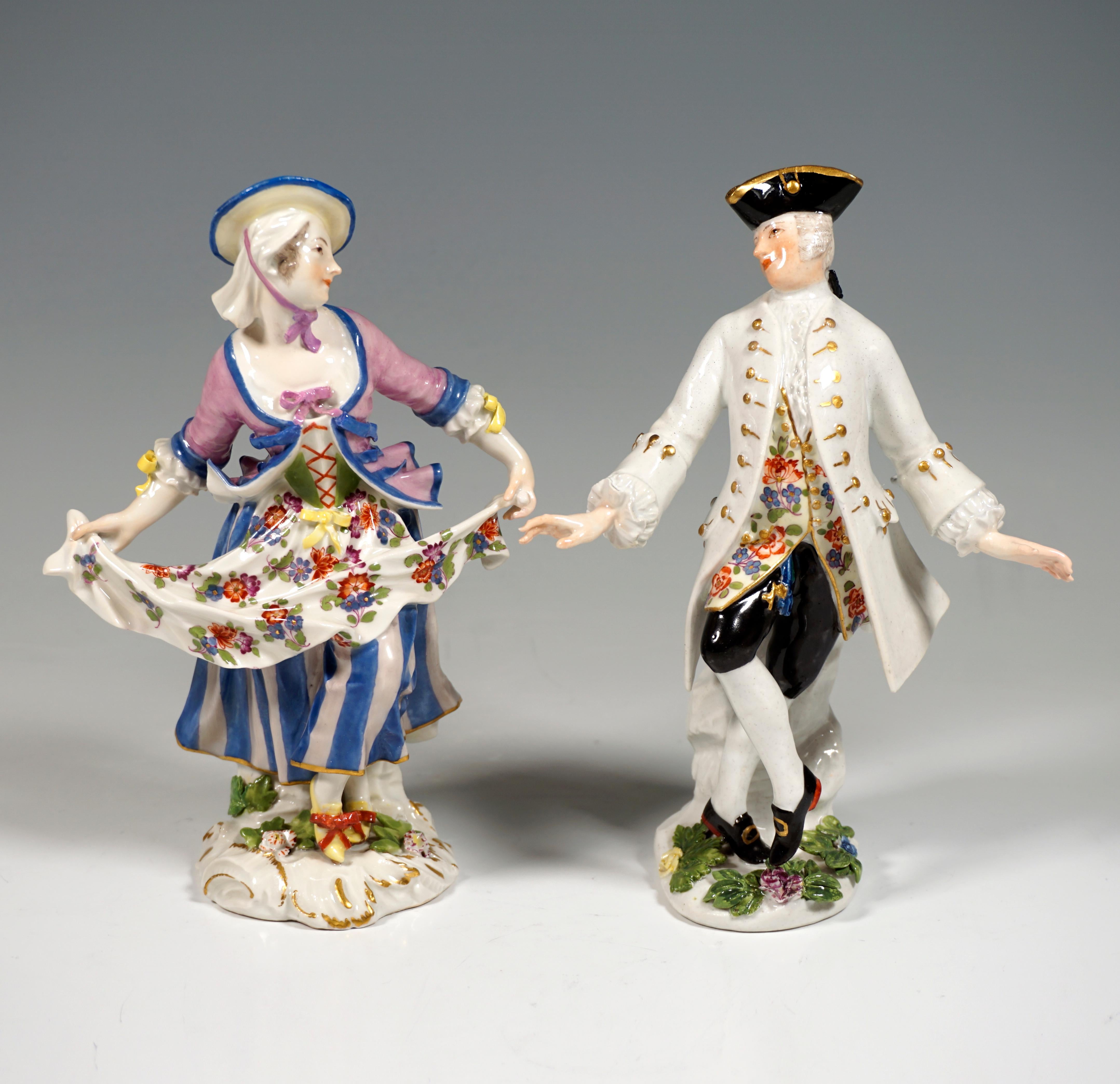 Galant dance couple consisting of two individual figures.
The female dancer wears rural Rococo clothing: a long, striped skirt with a bodice, a fitted vest over it, a flowered apron, which she holds up at the ends with her arms stretched out to the