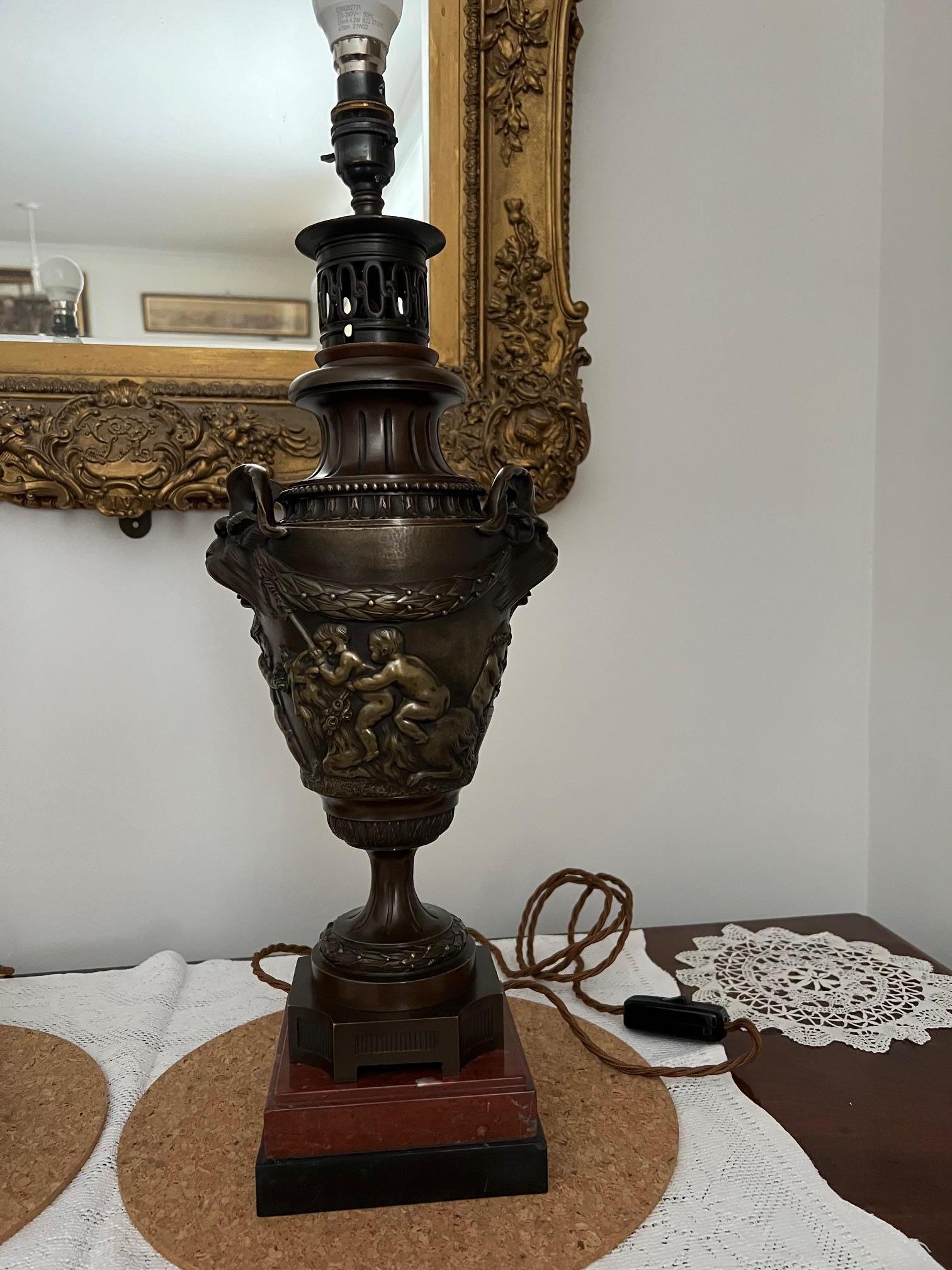 Wonderful bronze table lamps with mythical horned beast handles.

Body surrounded by cherubs cavorting and drinking, these showing some signs of polishing to surface.

Rest of lamps is a lovely nut brown patina.

Now fitted for electricity, PAT