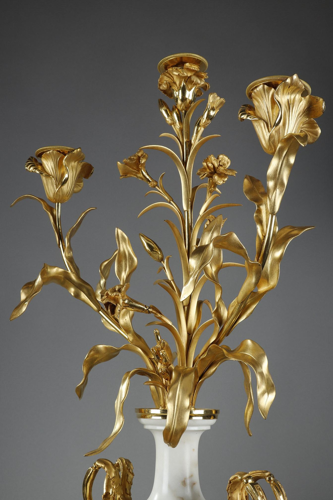Pair of candelabras in bronze and gilded and Marblewhite with three arms of lights in the form of a bouquet of flowers. The shaft in the shape of vase is decorated with two handles ending in acanthus leaves and a garland of vine branches on both