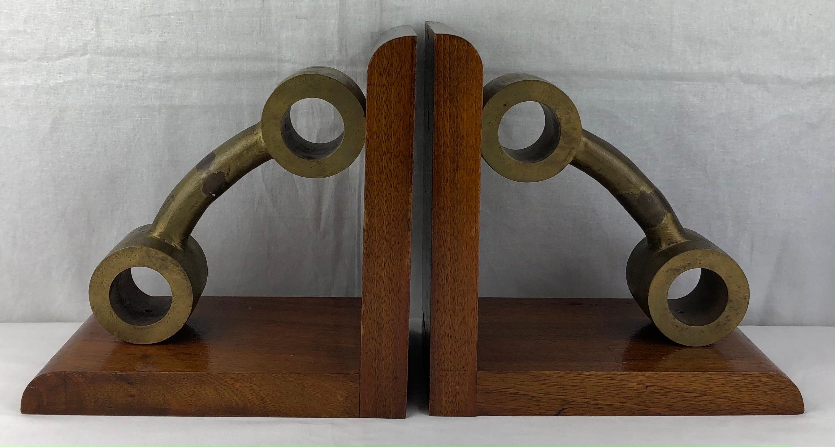 Ein großes, hochwertiges Paar französischer Art-Déco-Buchstützen aus Bronze und Mahagoniholz, um 1940. Erfreulich schwer.

Diese attraktiven Buchstützen zeigen scheinbar geformte Gewichte oder Hanteln. Sie machen sich wunderbar auf einer großen