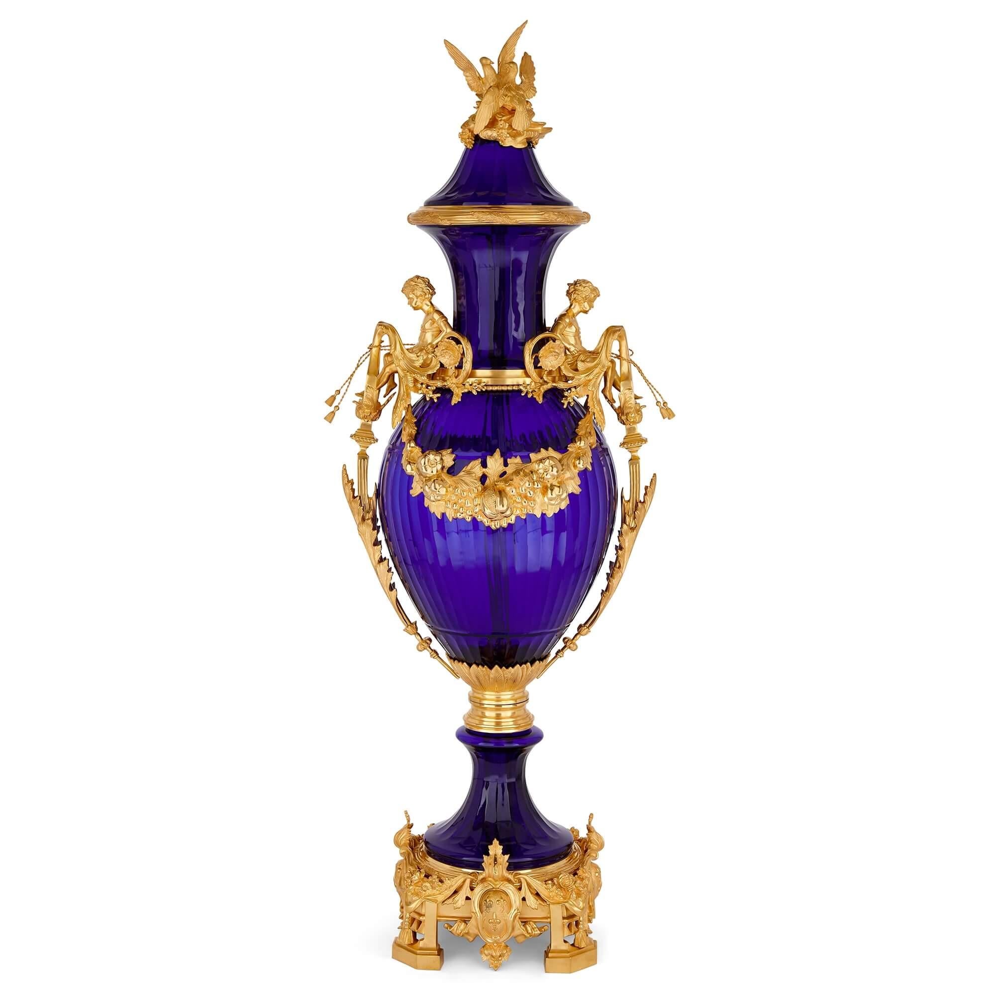 Coppia di vasi molto grandi in vetro blu francese e ormolo
Francese, XX secolo 
Altezza 153cm, larghezza 50cm, profondità 53cm

Il vetro blu e l'oro lucido dell'ormeggio si combinano per creare questa splendida coppia di vasi. Il loro design celebra