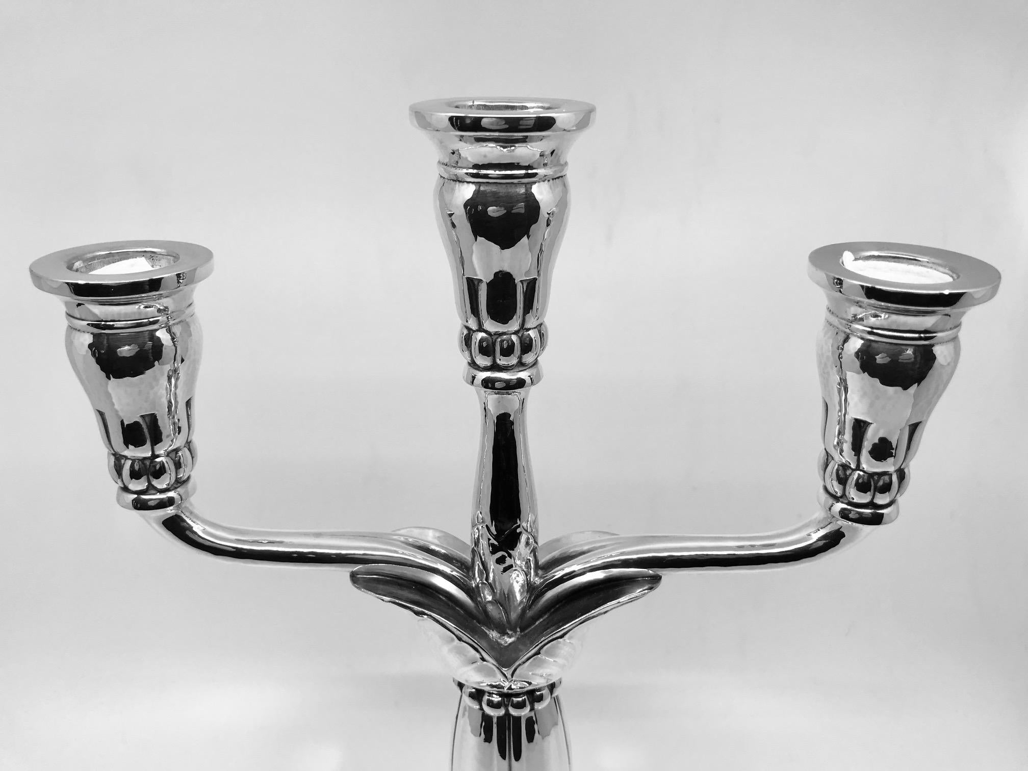 This is a pair of very rare sterling silver Georg Jensen Art Nouveau three-light candelabra, design #161 by Georg Jensen from circa 1912.

These candelabra are hollow and entirely handmade, ornamented with floral and beaded decorations.

Measure