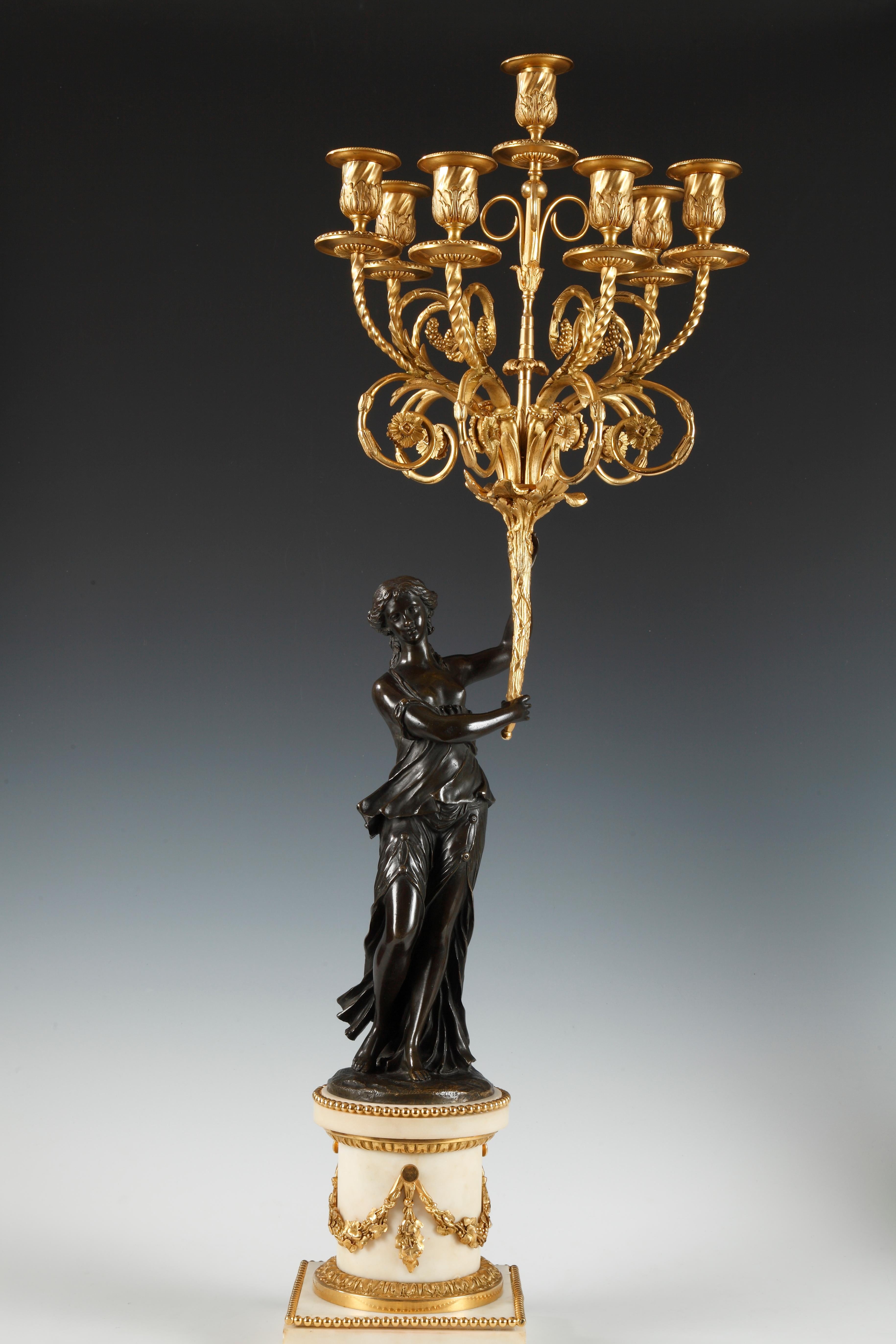 Pair of Louis XVI style seven lights candelabras made of chiseled and gilt bronze, realized after a model by Etienne-Maurice Falconet. Each candelabrum is composed of a feminine vestal figure, holding a cornucopia with finely chiseled arm lights,