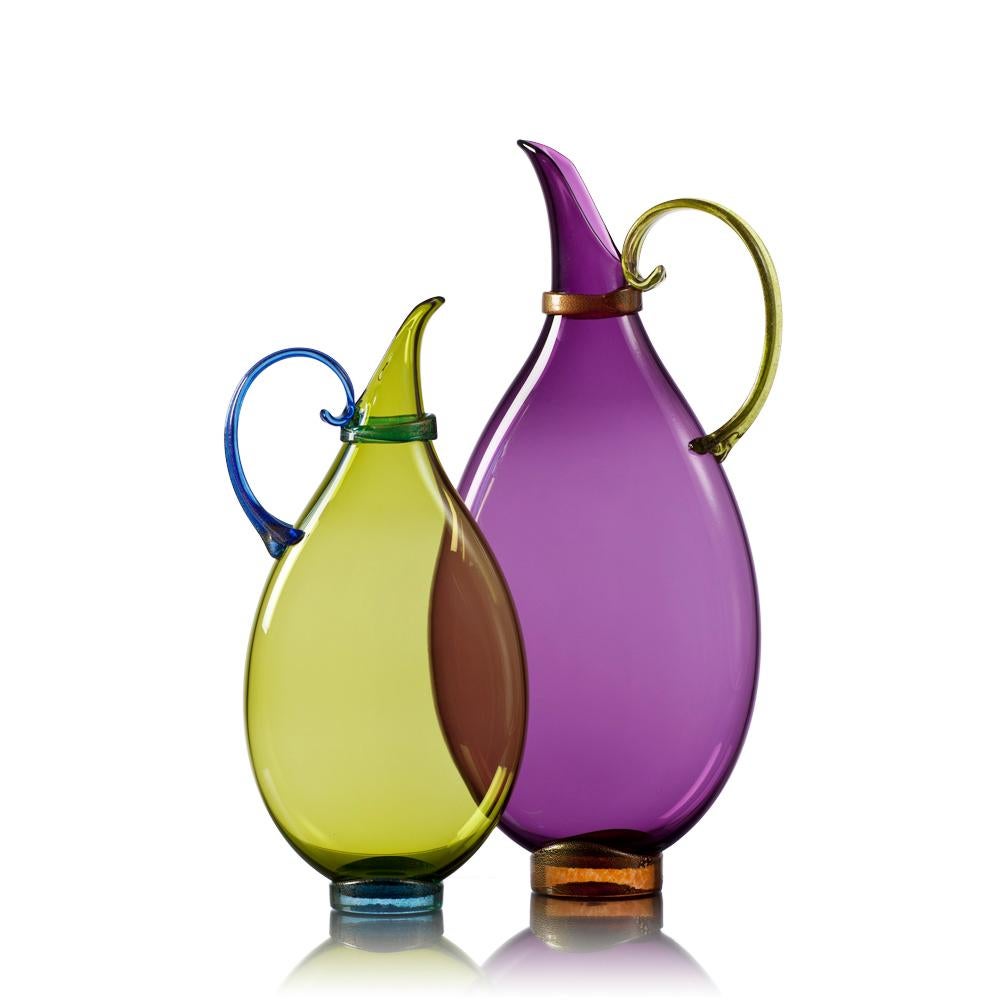 Assemble a set of two hand blown glass statement vessels in luminous glass hues with gold-leaf details. Each decorative vessel is flattened during the glassblowing process to inspire layered displays of translucent color. Choose from a complete