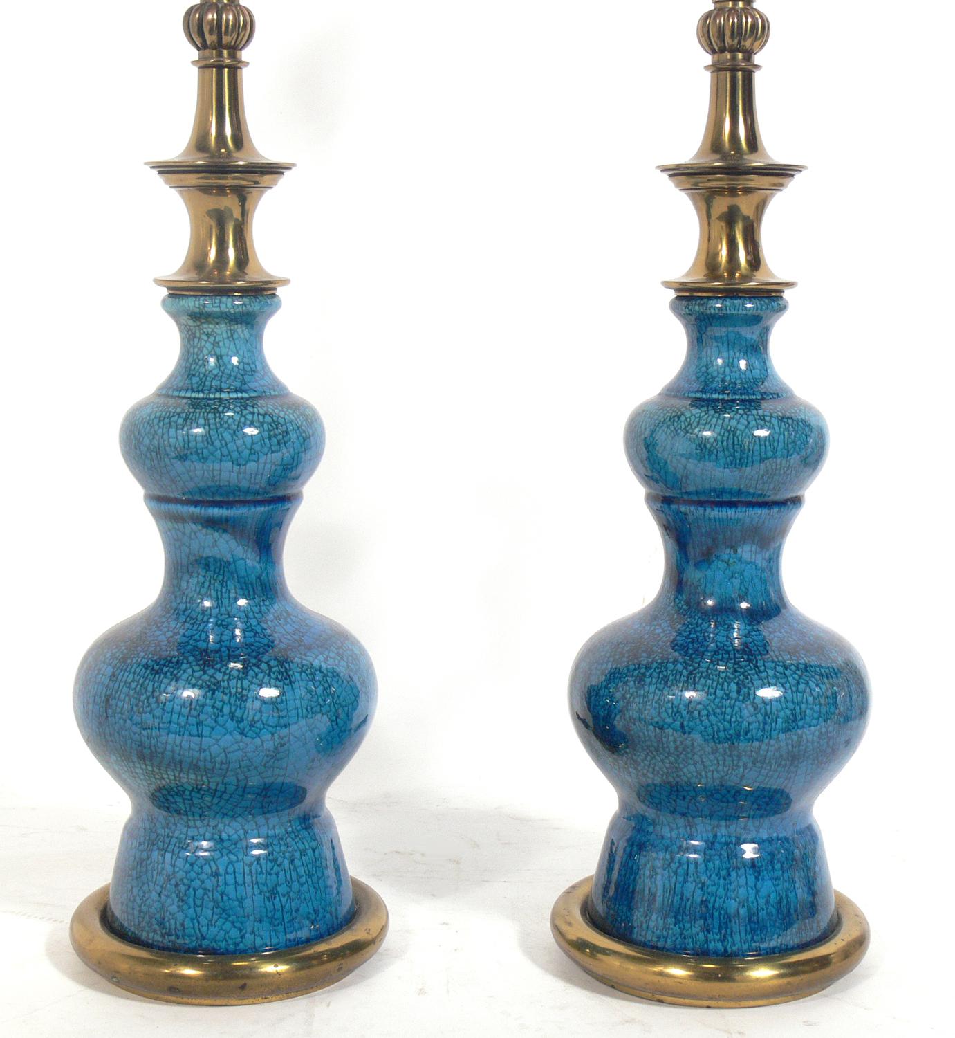 Pair of vibrant blue ceramic lamps, designed for Stiffel, circa 1950s. These lamps are executed in a vibrant blue color with a wonderful craquelure glaze. Nice heavyweight brass fittings with their original warm patina. The price noted in this