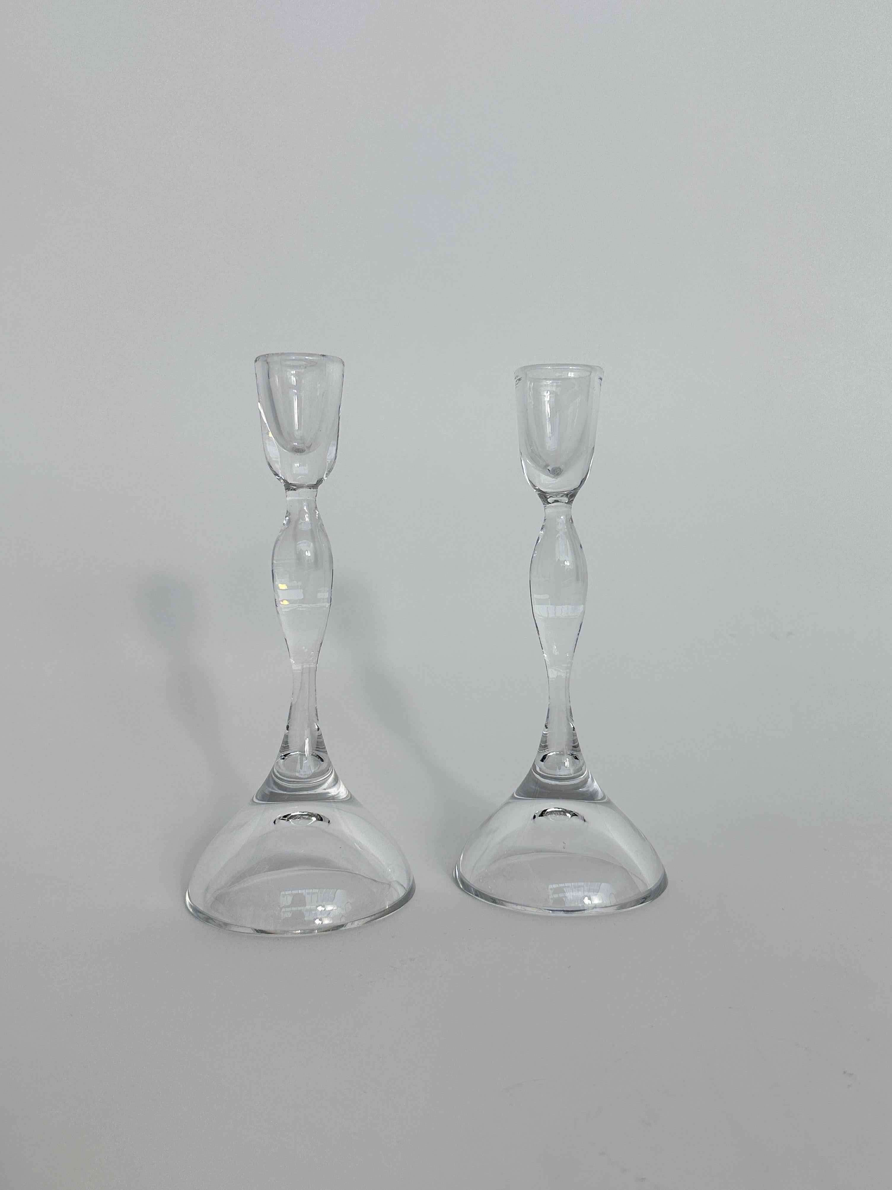 Ein Paar Kristallkerzenständer des Glasmeisters Vicke Lindstrand für Kosta in Schweden, Ende der 1950er bis Anfang der 1960er Jahre.
 
Darunter unterschrieben.
 
Höhe: 21 cm
Für Kerzen mit einem Durchmesser von 2 cm