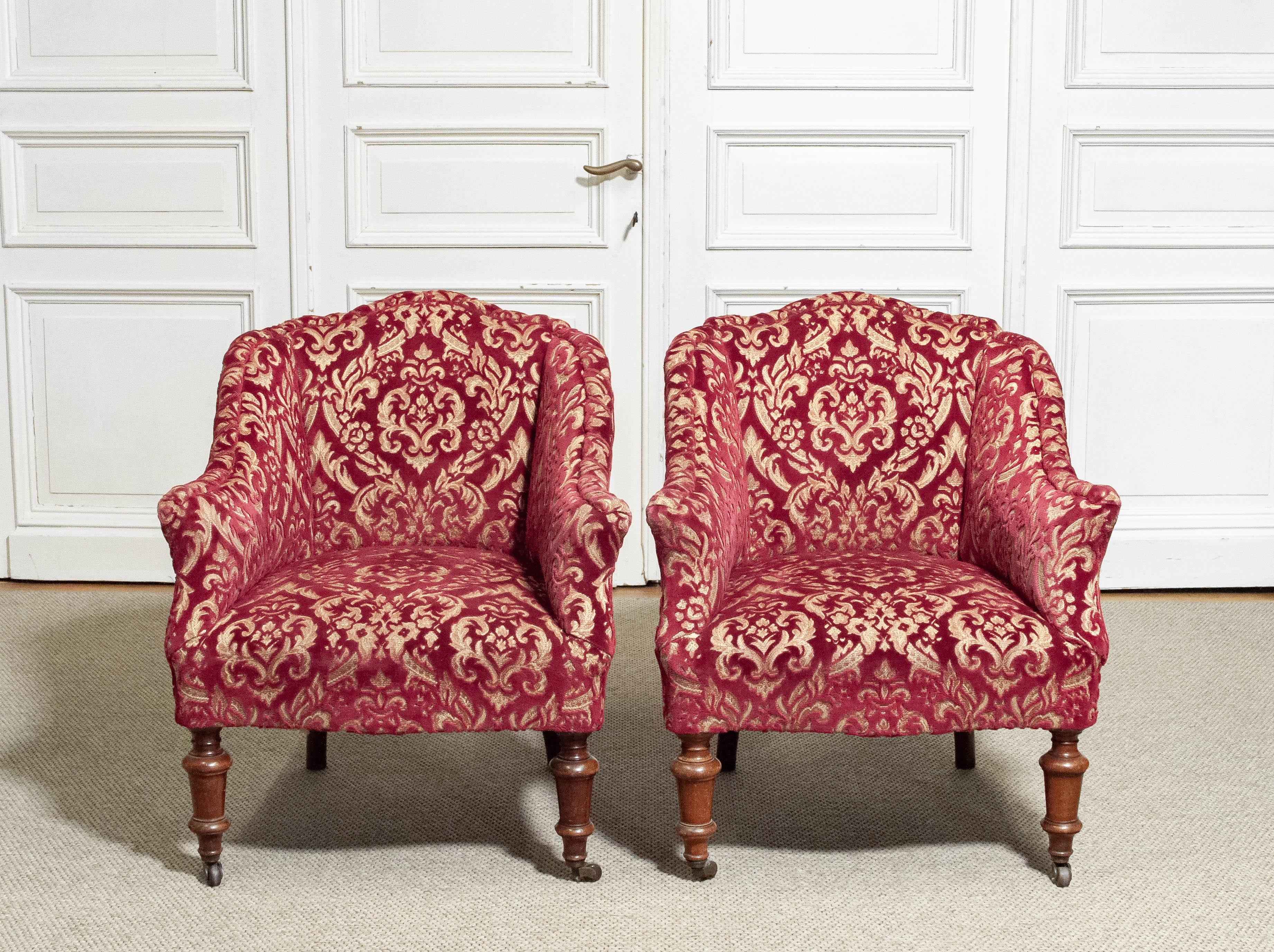 Elegant Victorian armchairs dating from the 1850s, crafted in a style that blends both Victorian and Louis influences. The chairs feature beautifully turned front legs with original wooden castors, and gently curved backs and arms typical of the