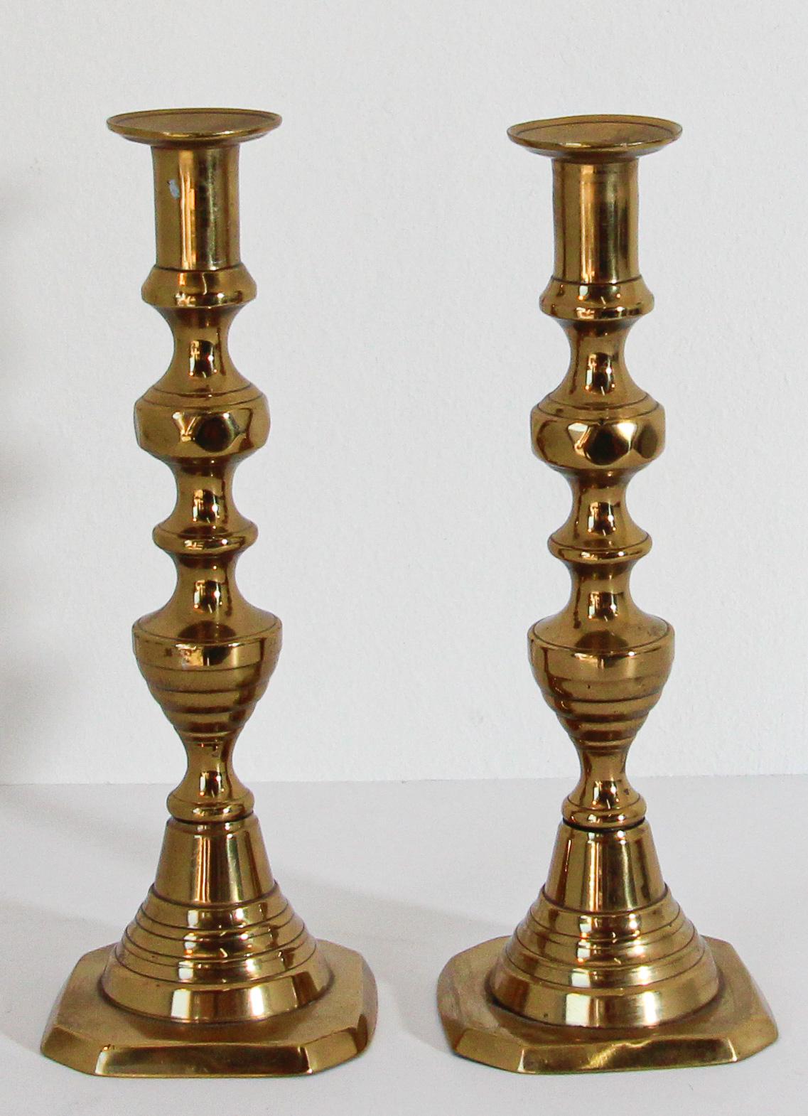 Pair of Victorian English polished brass candlesticks.
19th Century Pair of hollow core cast brass beehive candlesticks with a classic urn form candle cut with bobeshe.
Below the bobeshe is a diamond facetted knob on a beehive turning which is