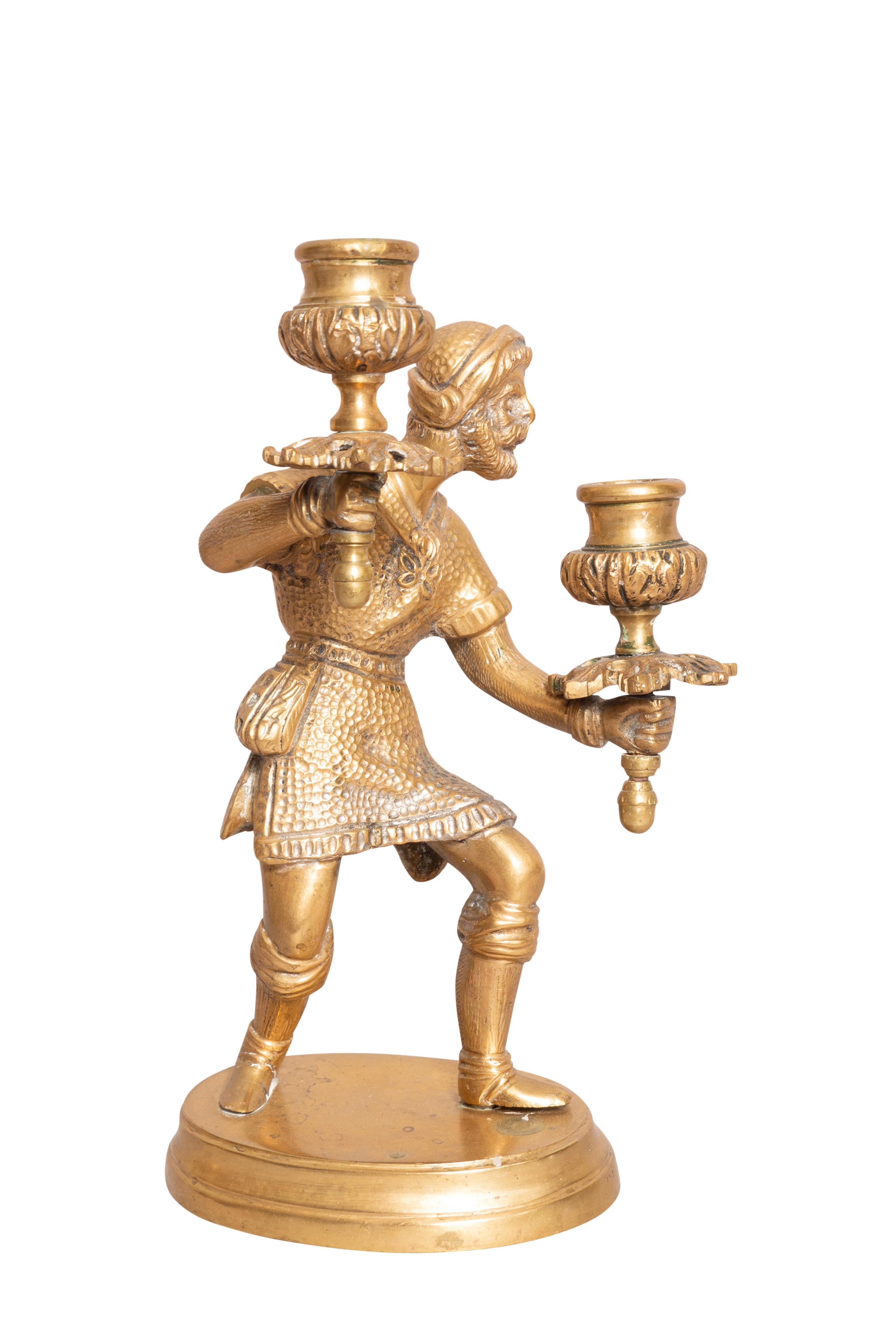 Each male figure in medieval dress holding two candle holders. Oval bases. From the estate of founder of Yankee Candle Company.