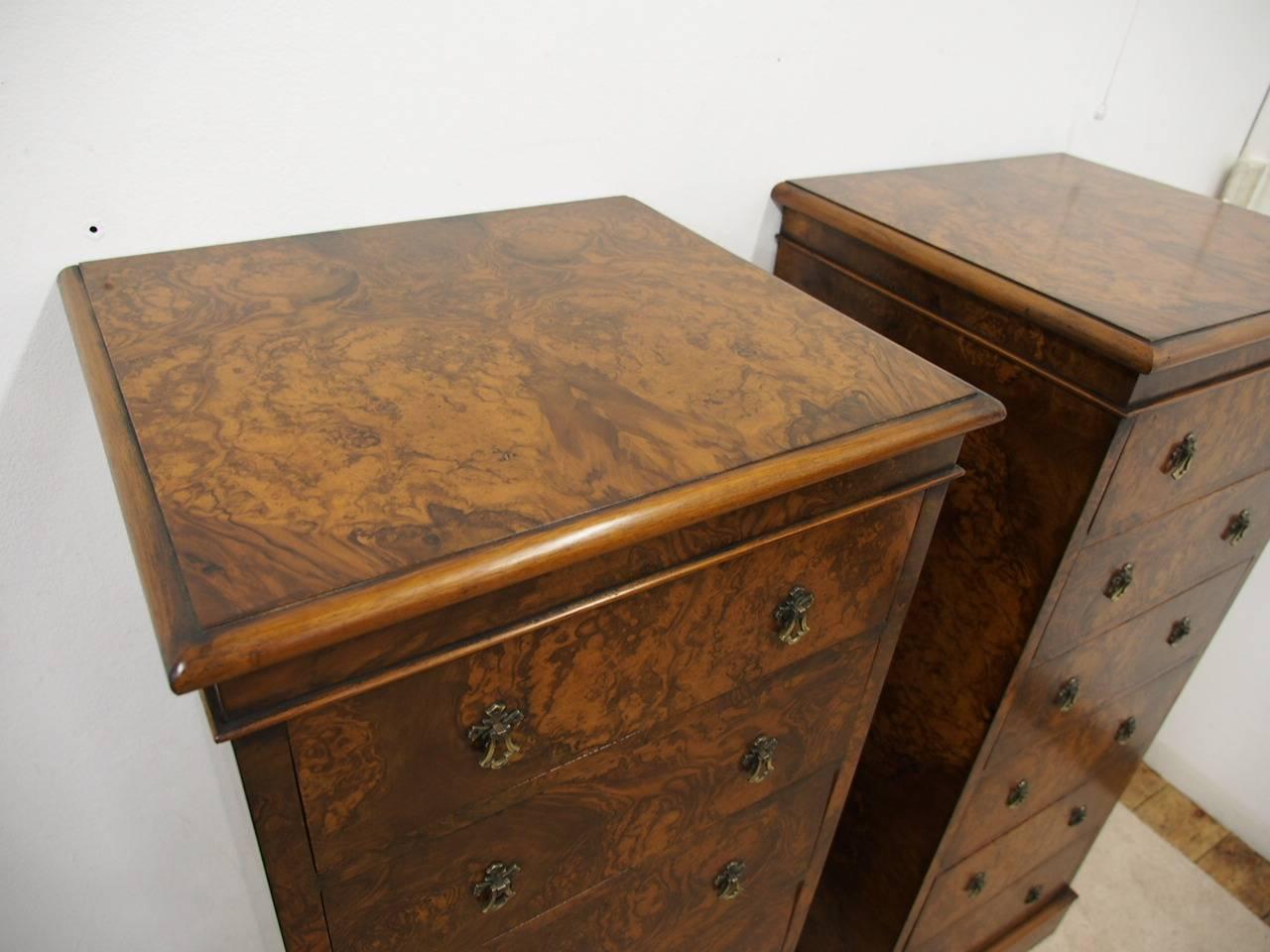 Rare pair of late Victorian burr walnut, tall chest of drawers, circa 1890s with alterations. Made in the wellington chest style, each has six graduated drawers and their original brass drop handles. The rectangular top with a rounded moulding sits