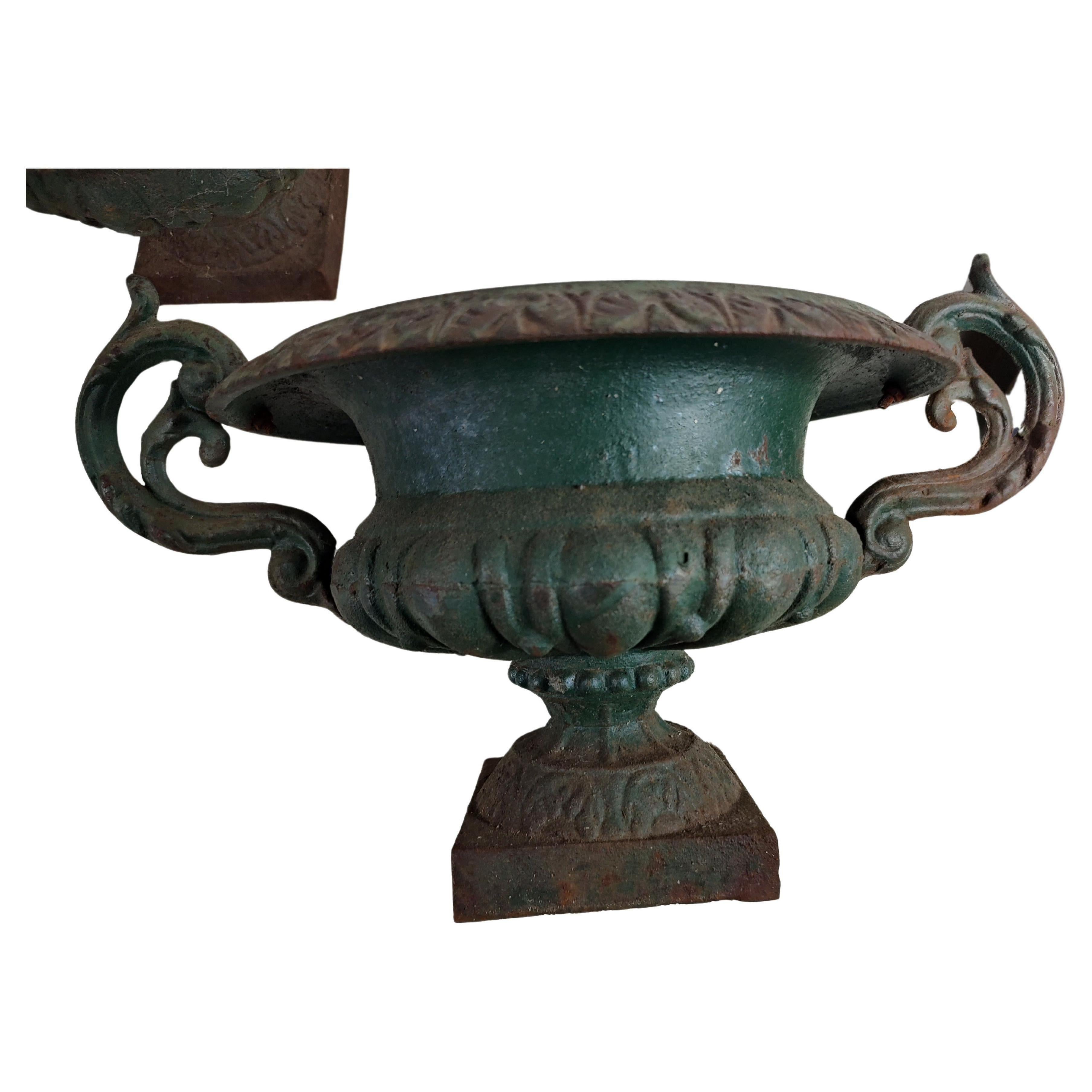 Simple and elegant petite pair of late Victorian cast iron garden urns in old green paint. In excellent vintage condition with minimal wear, no cracks or breaks no bad repairs, just lots of old patina and some rust. Priced and sold by the pair.