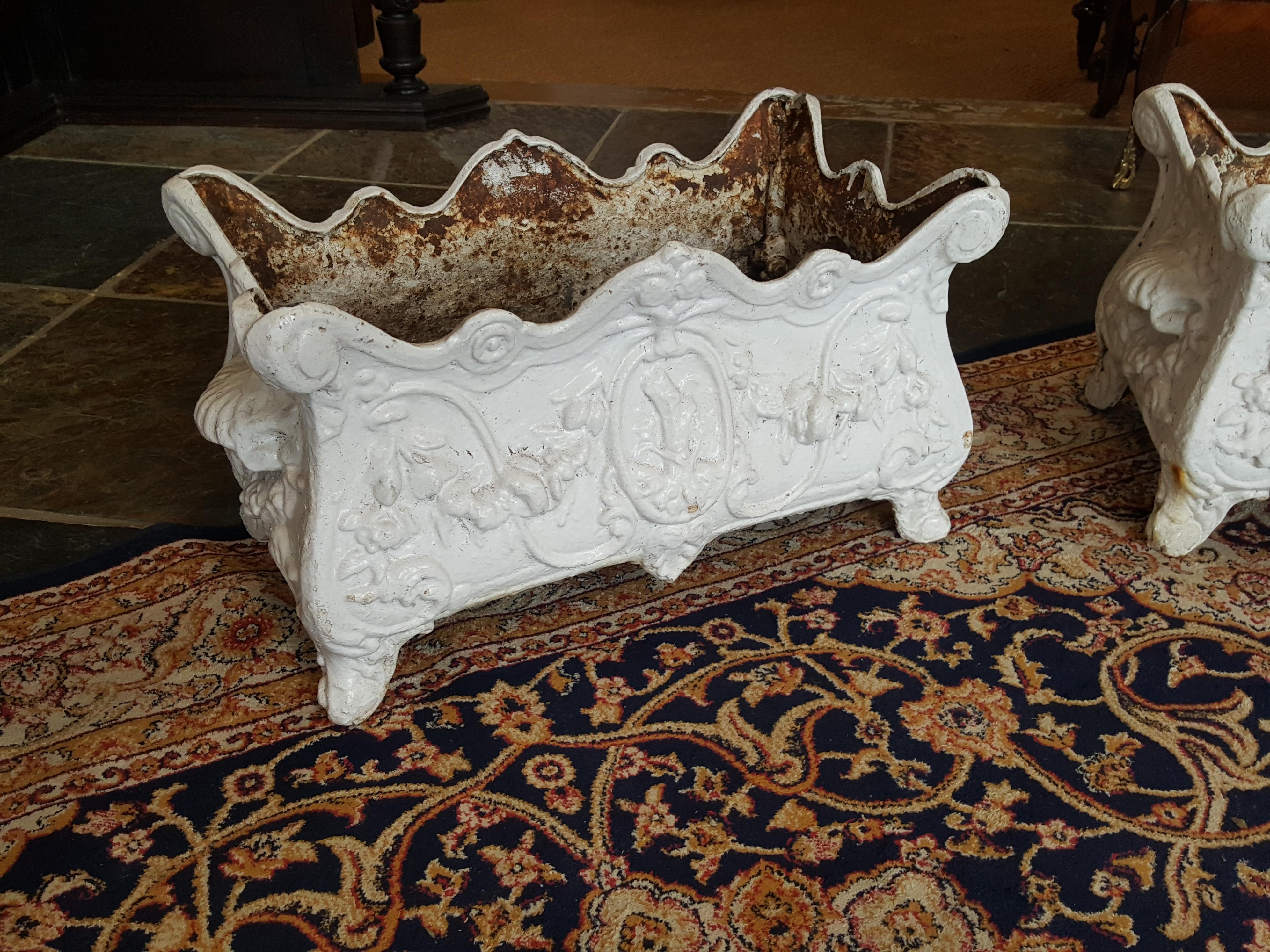 A pair of Victorian cast iron planters of oblong form with wavy rims and shell handles to the ends,
Measure: 21