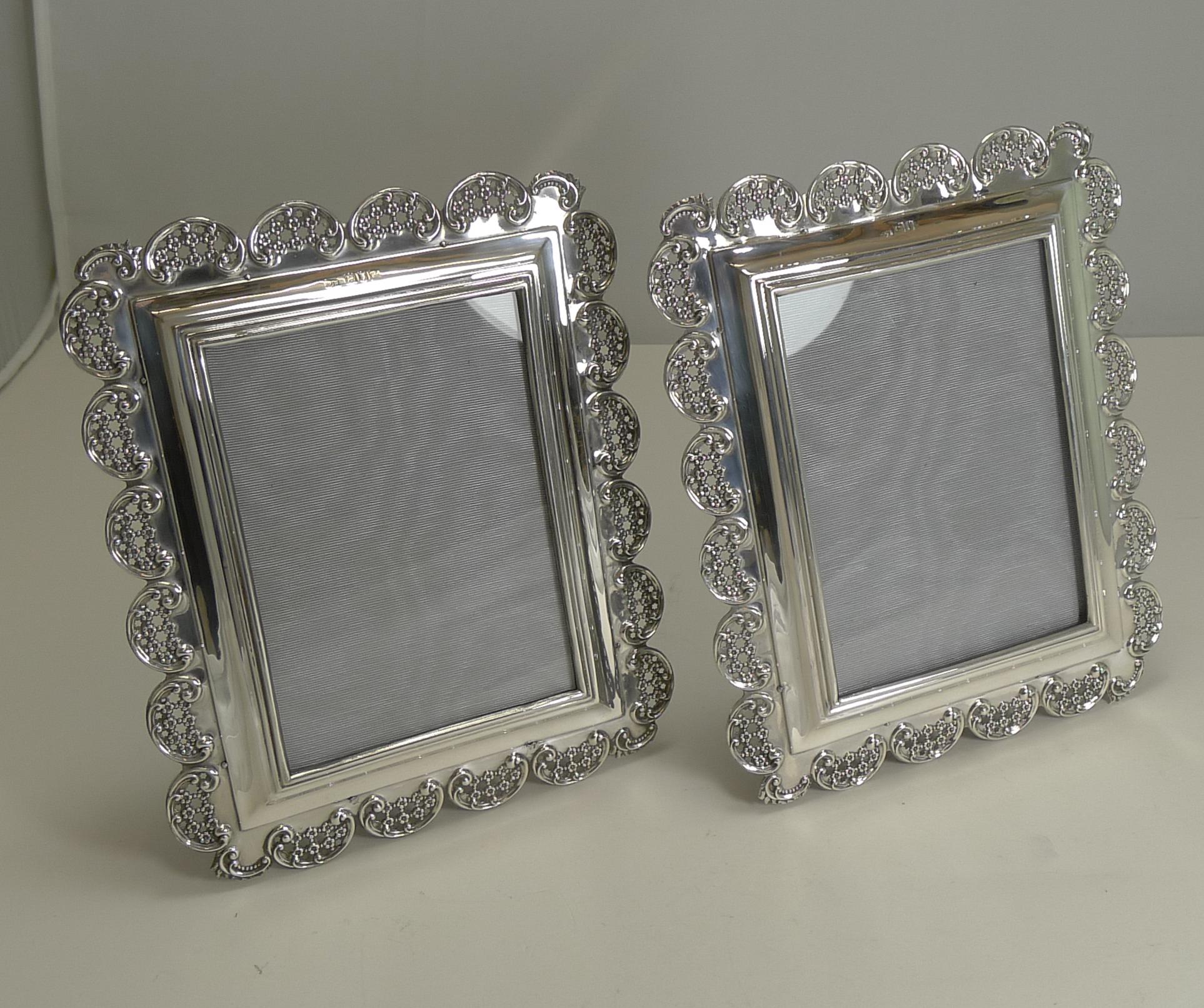 A stunning pair of late Victorian photograph frames, lovely quality with an intricate cast silver scalloped border created from a series of reticulated panels with tiny floral motifs within.

Each of the frames is fully hallmarked for London 1898