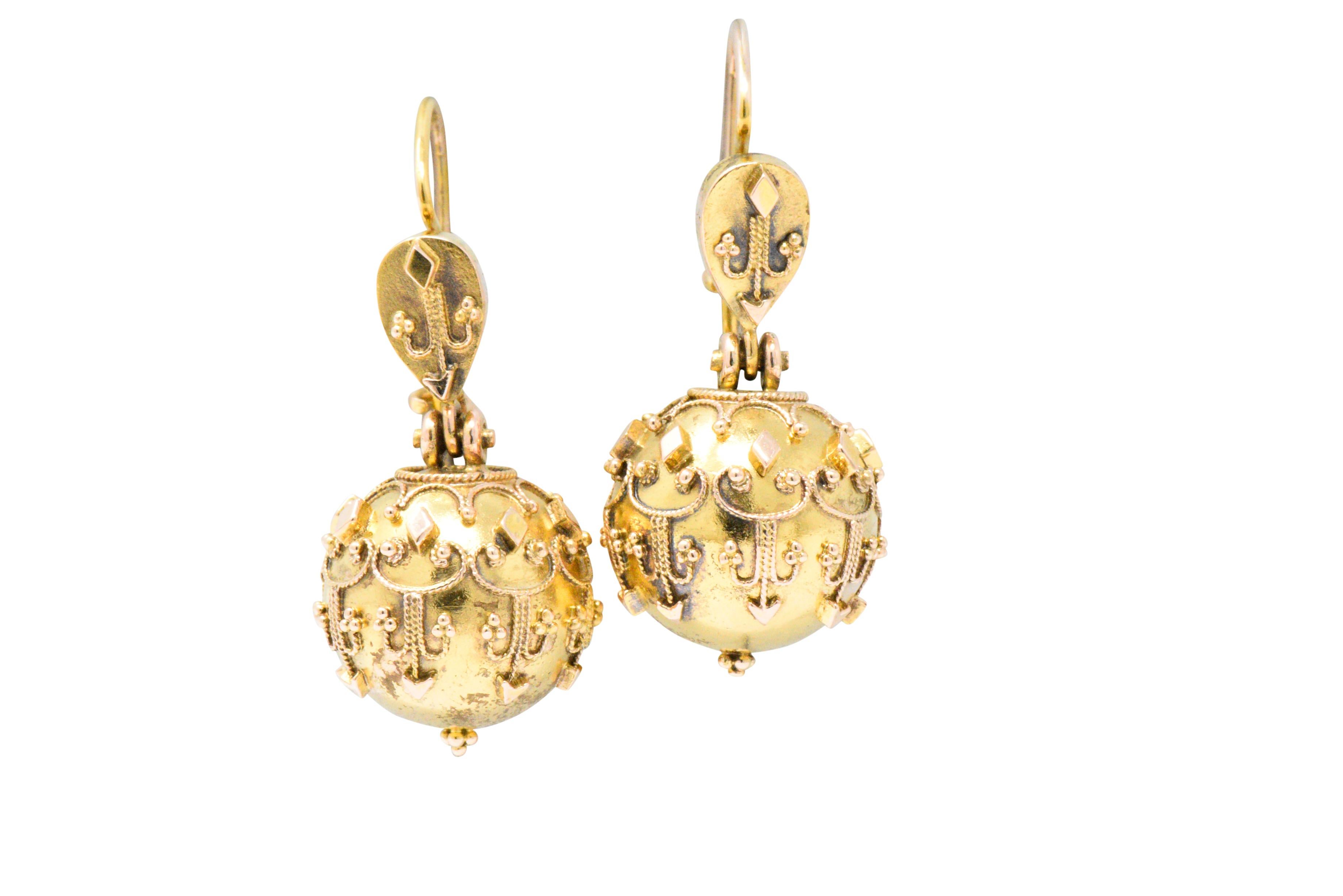 Designed as decorative fluer-de-lis surmounts

Suspending articulated gold spheres with ornate scrolled foliate and applied bead detail 

Completed by hooks with closure

Tested as 14 karat gold

Circa: 1870

Measures: 1/2 x 1 1/4 inches

Total