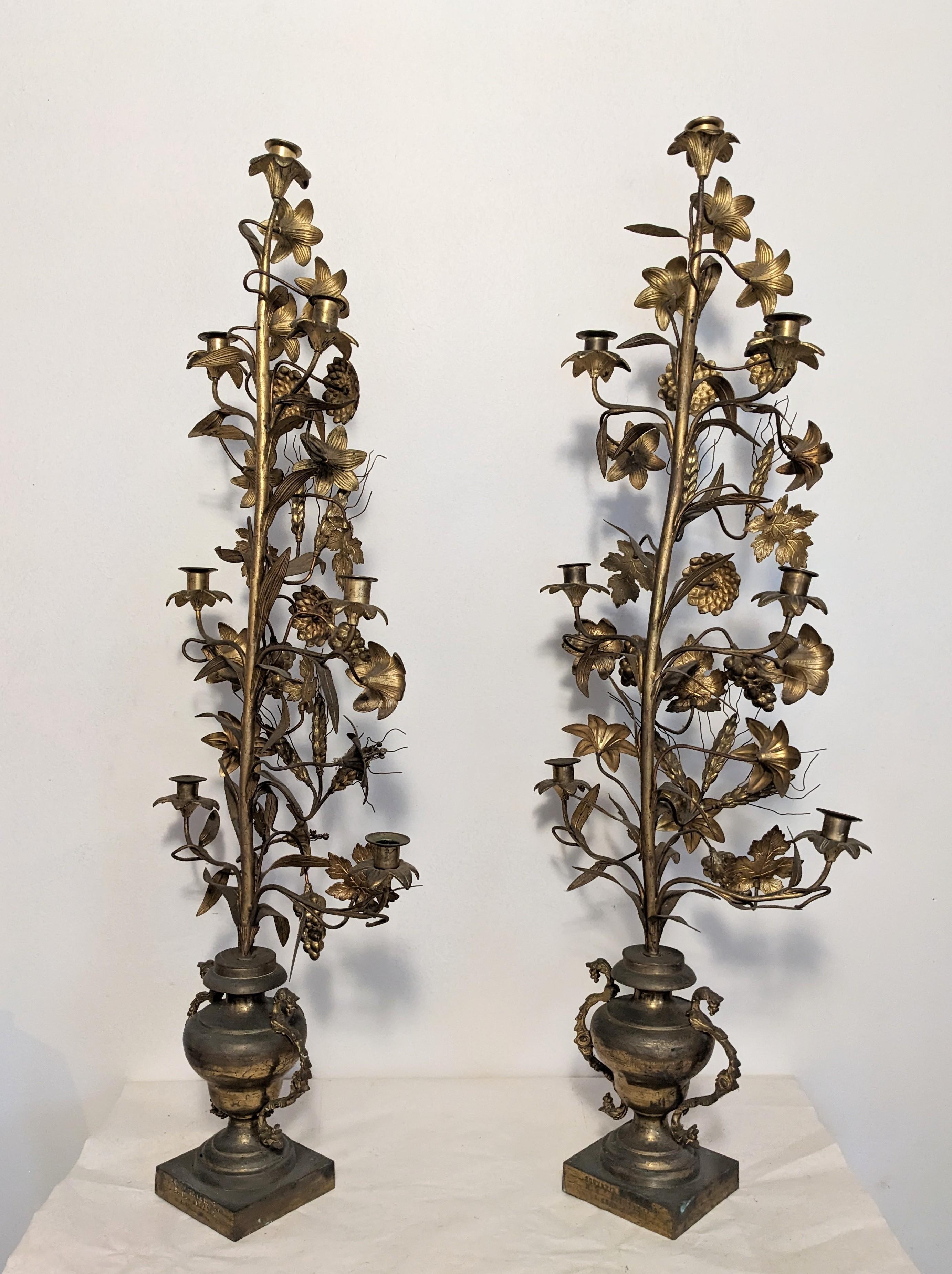 Striking pair of Victorian French bronze candleabra, Marriage Gift from the late 19th Century. Heavy bronze bases with family cartouche and brass floral topiaries with a multitude of different flowers and wheat motifs above. Inscribed with dates on