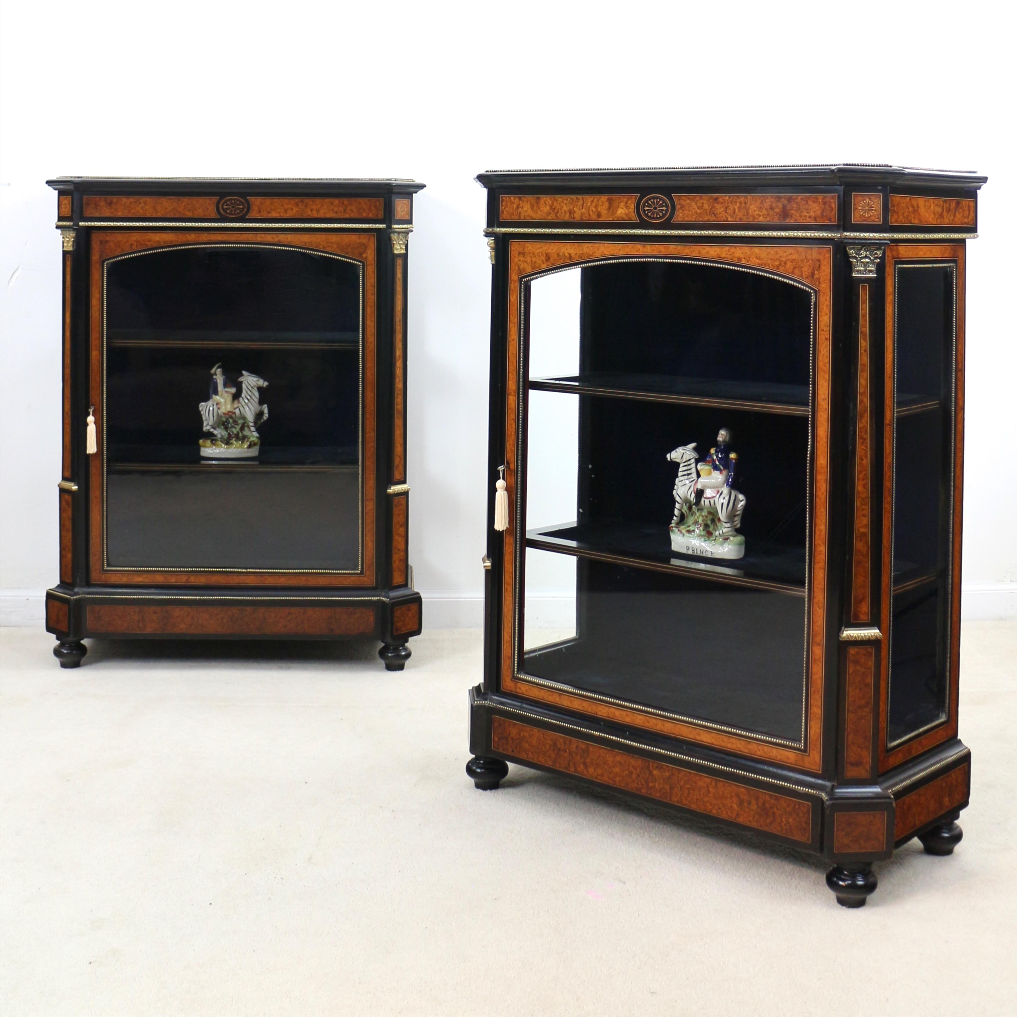 A beautiful pair of ebonised and amboyna inlaid pier cabinets dating to the mid Victorian period. Rarely found with glass sides this pair of cabinets are superbly made featuring finely inlaid paterae with beautifully figured amboyna inlays bounded