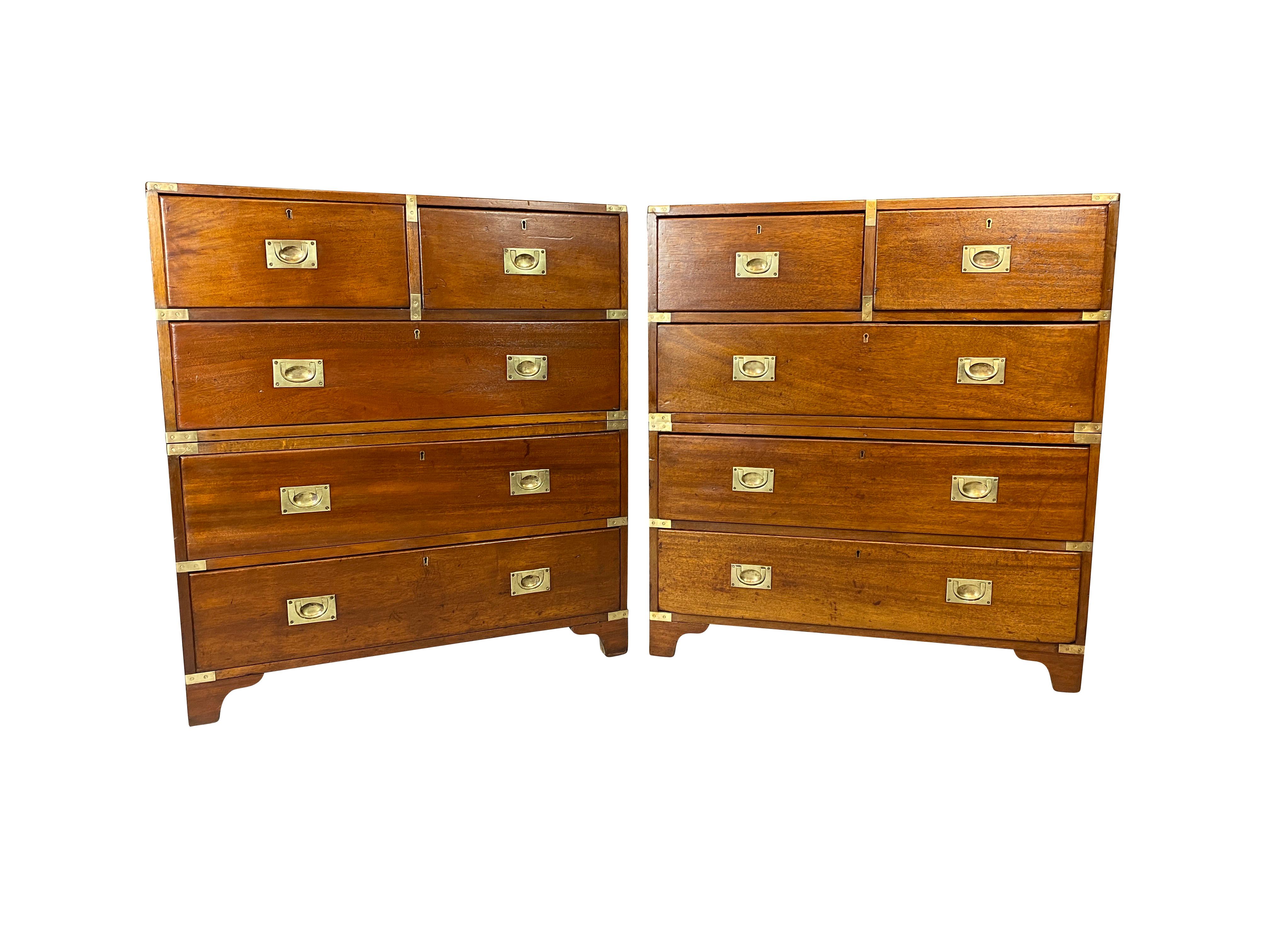 Each with rectangular tops with brass corners over two over three drawers all with recessed brass handles. In two parts, bracket feet.