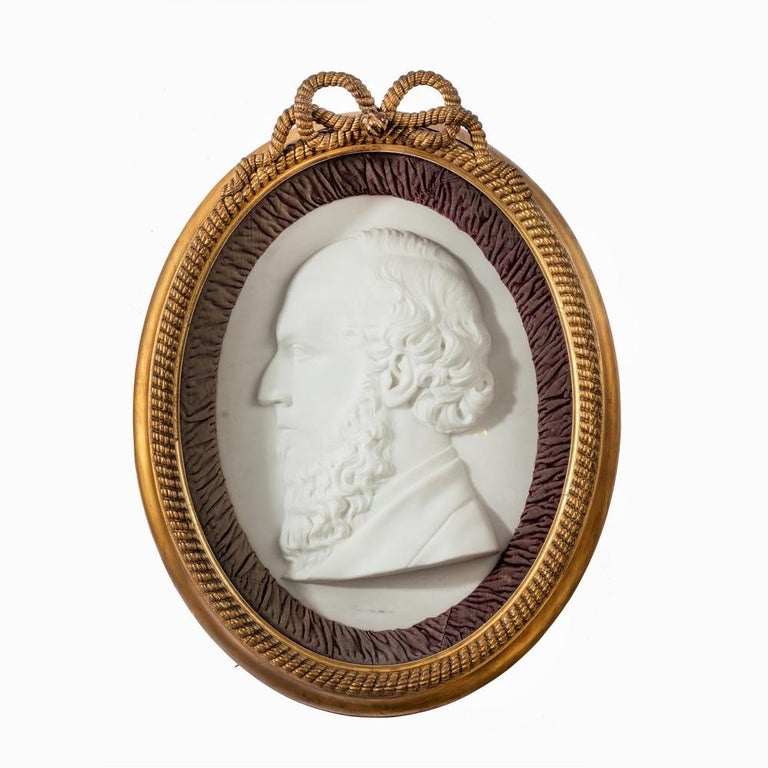 A pair of Victorian marble portrait plaques. An attractive pair of Victorian oval white marble portrait plaques. Each in its original giltwood rope-twist and red velvet frame.