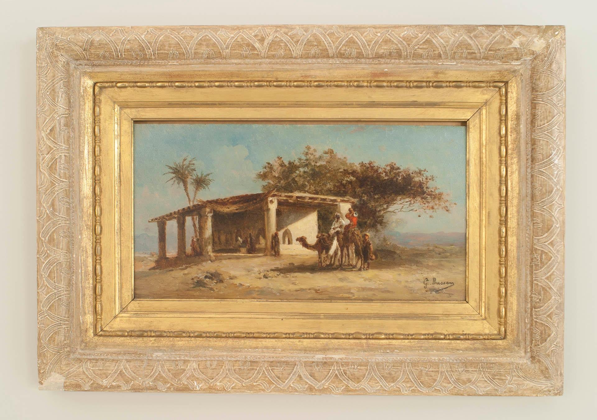 Pair of French Victorian oil painting of a Middle Eastern scene with figures and camels standing next to a building (signed: G BUSSEN).
 