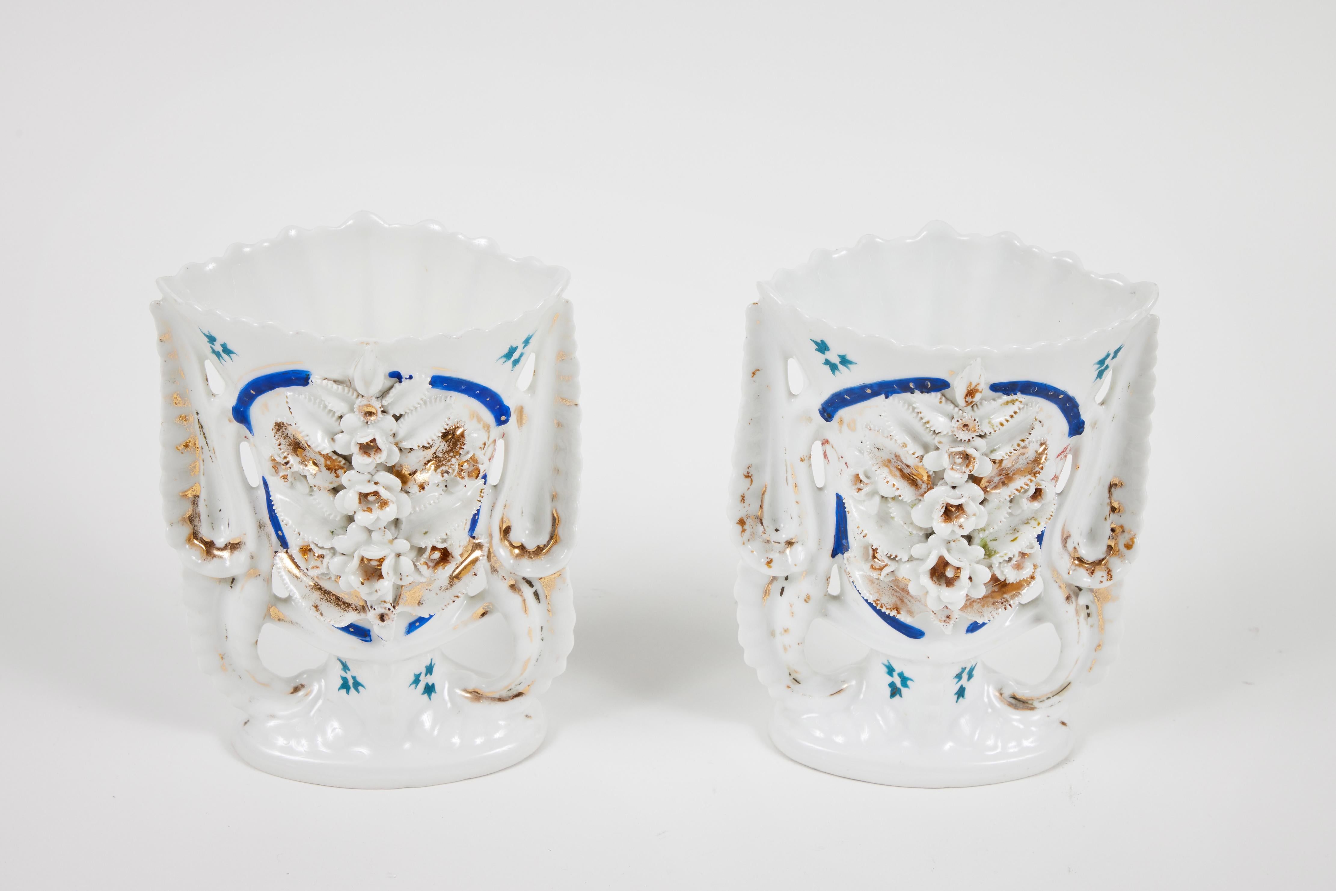 Showcase your flowers in our pair of intricately decorated Victorian porcelain mantel vases. They are meticulously adorned with 3 dimensional flowers, leaves and beaded accents and rim. These vases are white with accents of teal, cobalt and gold. An