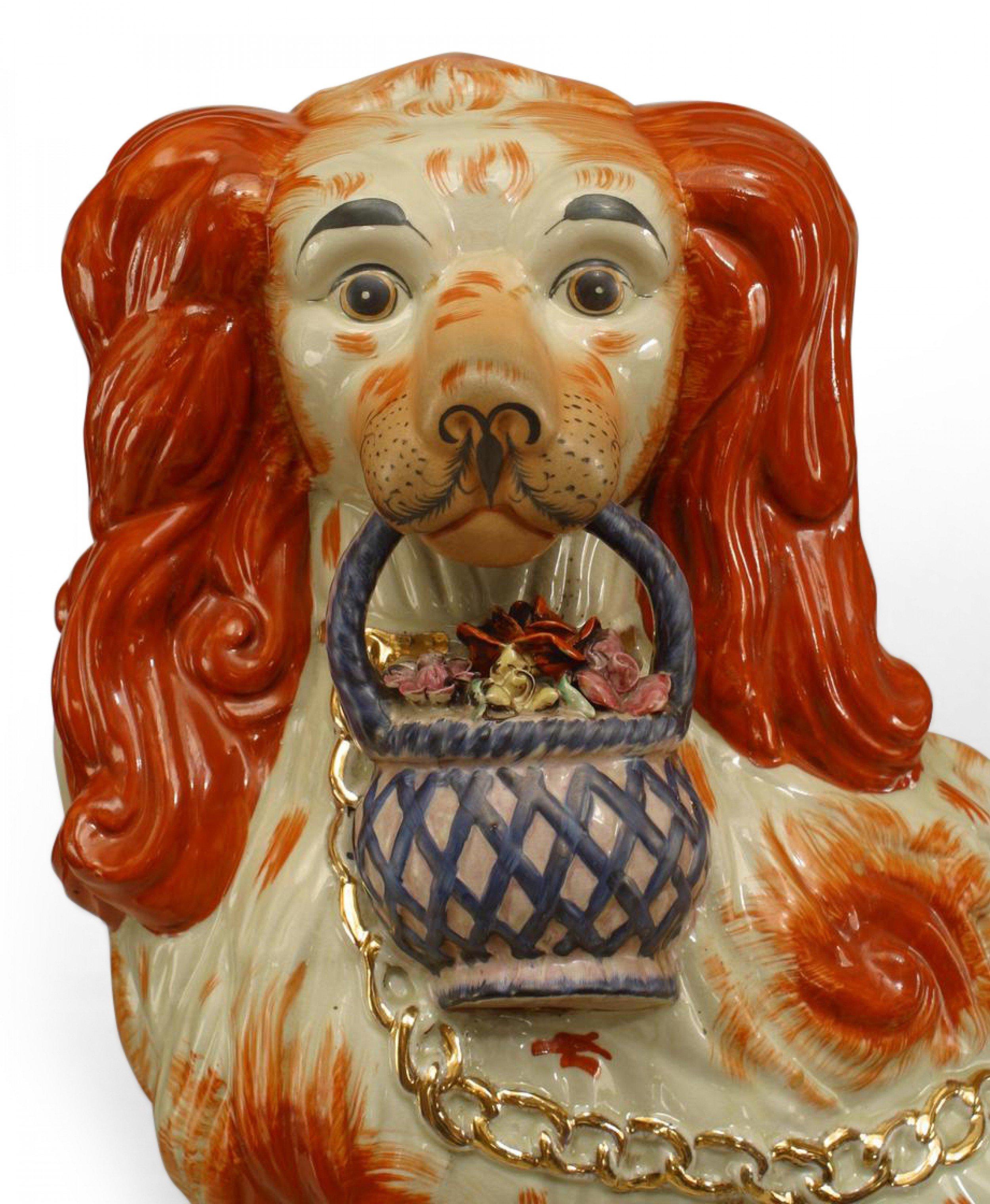 Paire de grandes figurines en porcelaine anglaise de style victorien (19e/20e siècle) Staffordshire représentant des épagneuls orange et blancs assis tenant des paniers de fleurs dans leur bouche avec des laisses en chaîne dorée.
