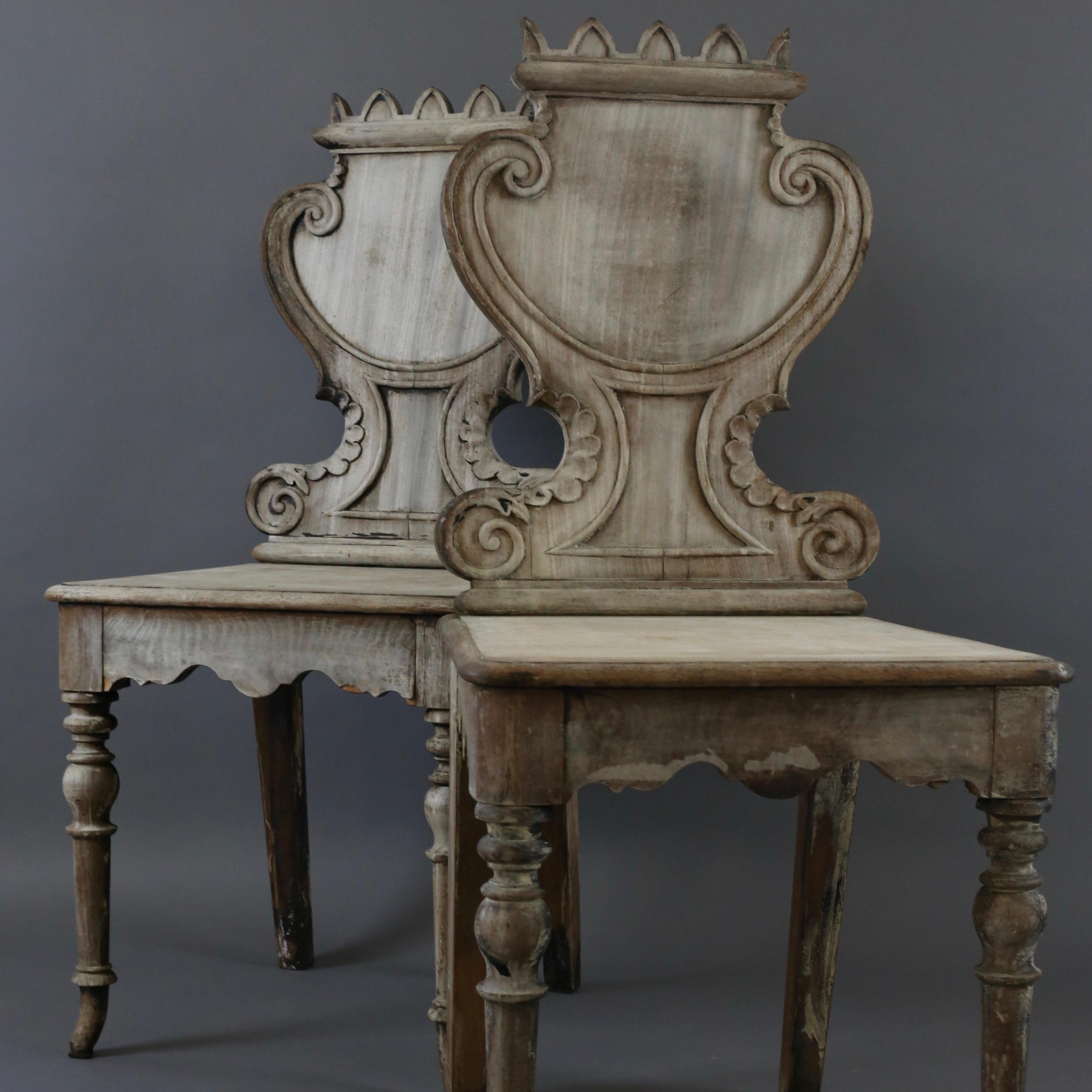 Pair of antique Victorian shield back highly decorative hall chairs in bleached oak, believed to be Irish. Very charming.

 