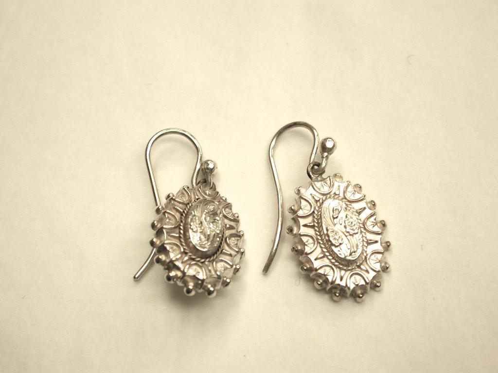 Pair of antique Victorian silver earrings with leaf work in centre and etruscian decoration
around the outside, dated circa 1880.