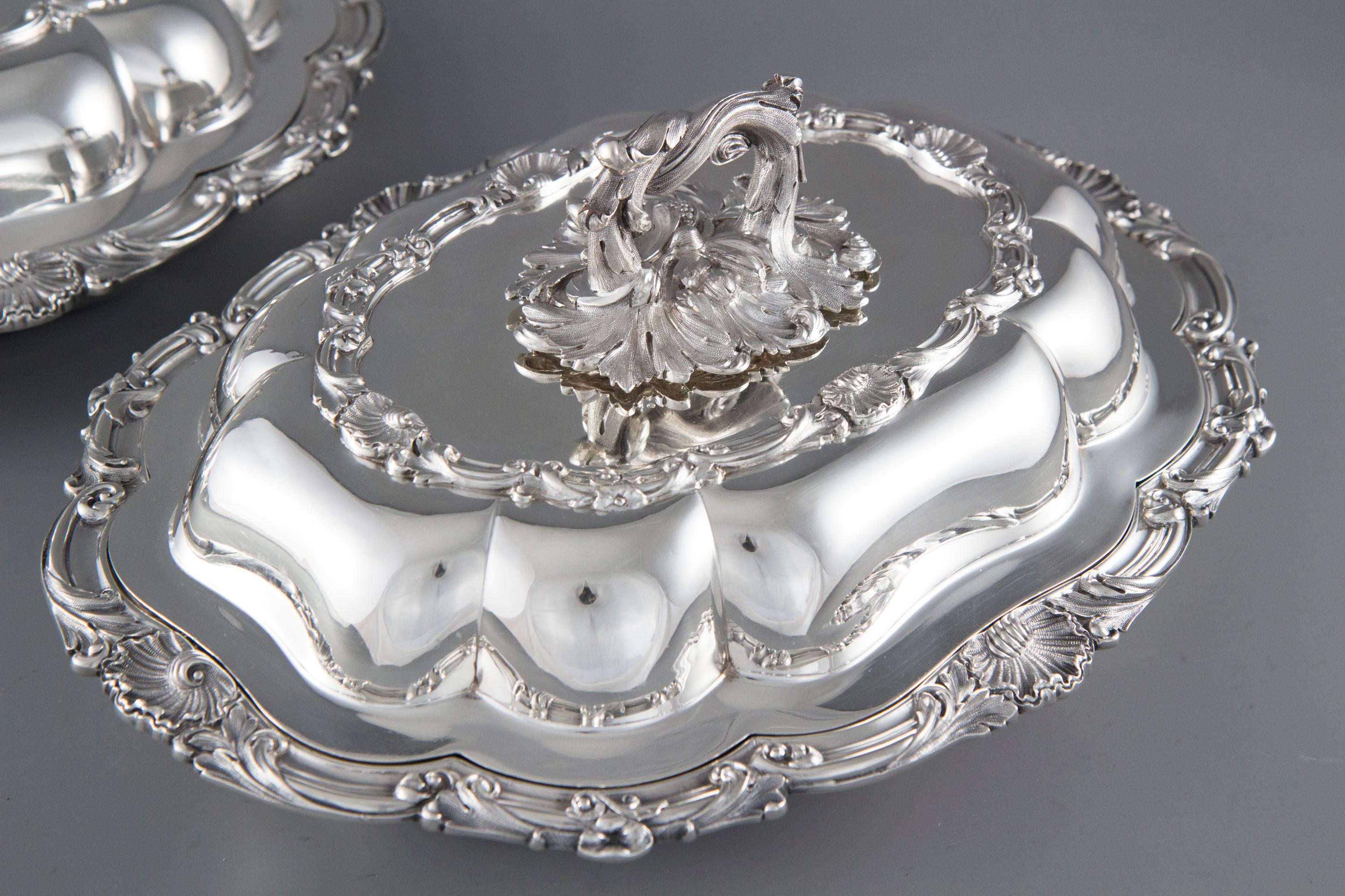 A very good quality pair of mid-Victorian silver entree dishes of shaped oval form. The borders cast with scallops and scrolling foliage. The twist- off cast silver handles with serpentine foliate decoration and fruit and foliate bases.

Each dish