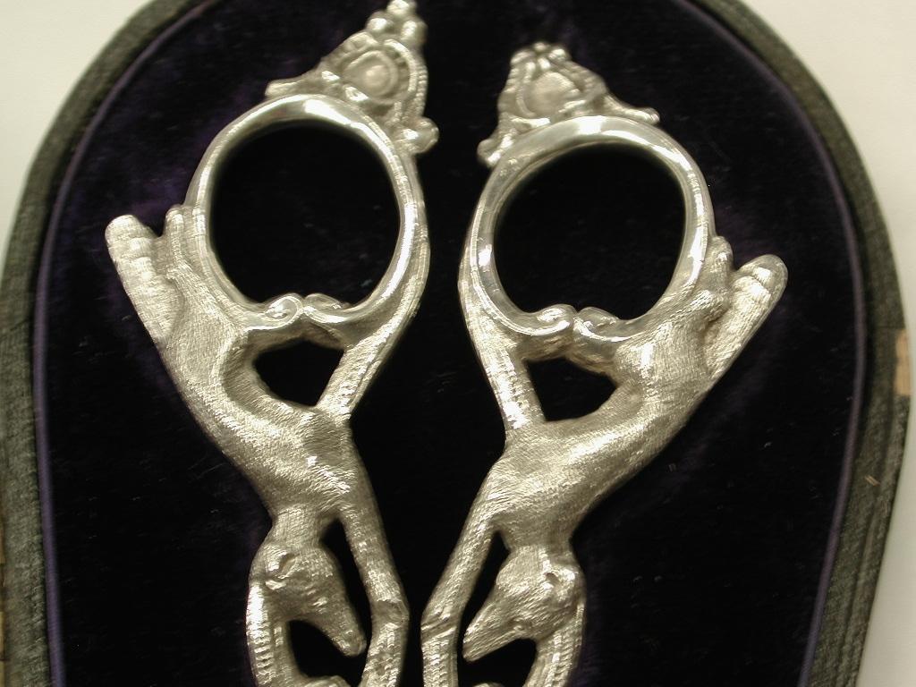 Heavy quality pair of silver grape shears in a fitted leather box, by Walker and Hall of Sheffield.
The fox and grapes theme is from one of Aesops fables which tells the story of a
fox who sees a bunch of grapes hanging from a vine and after several