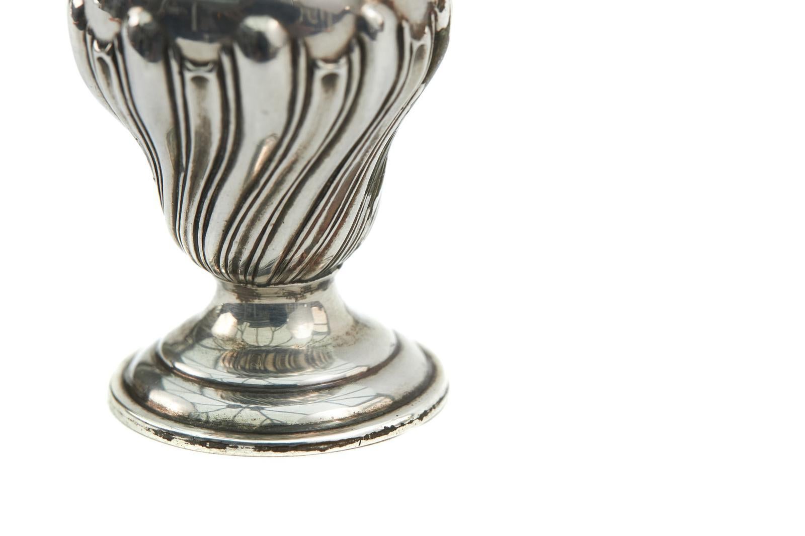 Pareja de pimenteros victorianos del siglo XIX, de plata antigua, con la parte superior desmontable sobre un cuerpo acanalado y decorado, que descansan sobre bases circulares escalonadas. Con matasellos de Birmingham 1876.
